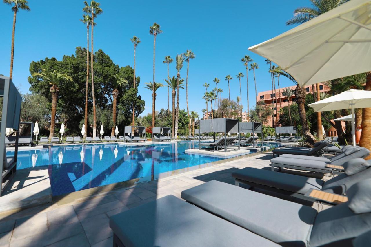 Outdoor swimming pool surrounded by sunbeds at the Kenzi Farah Rose Garden