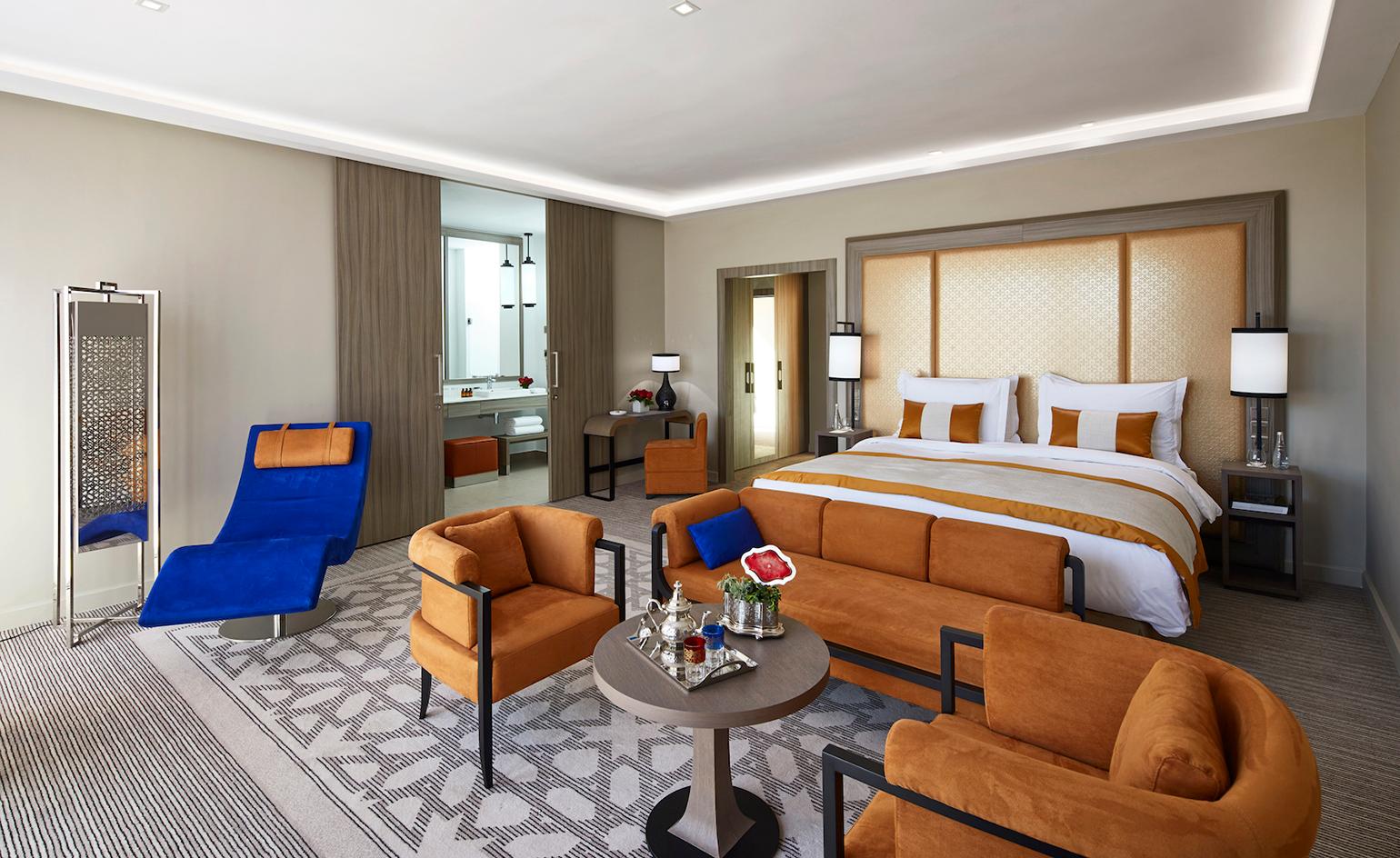 Luxurious double bed room with a lounging area at Movenpick Mansour Eddahbi Hotel