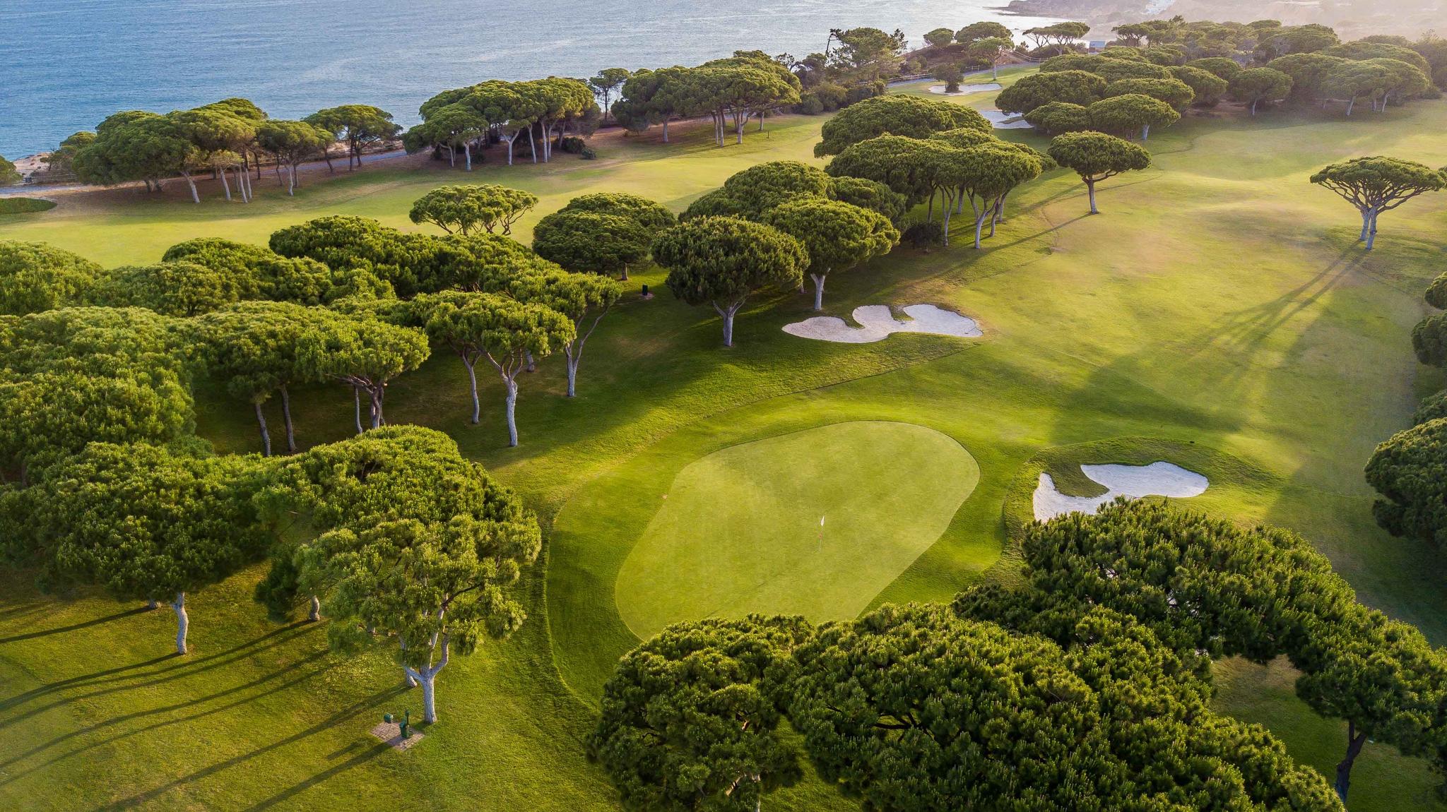 Aerial view of a well maintained fairway leading to a smooth green surrounded by sand bunkers