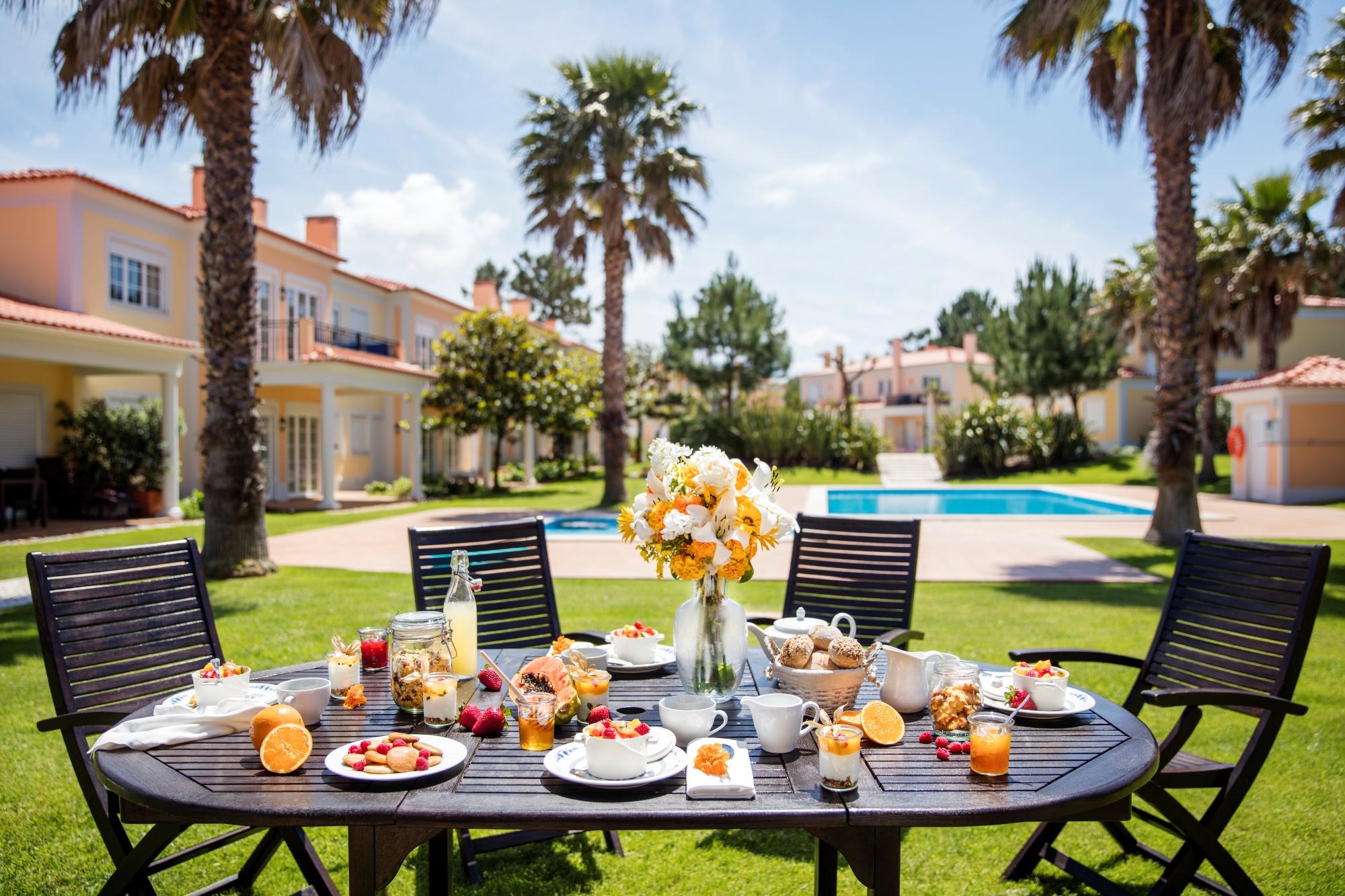 Outdoor dining area with palm trees and swimming pool