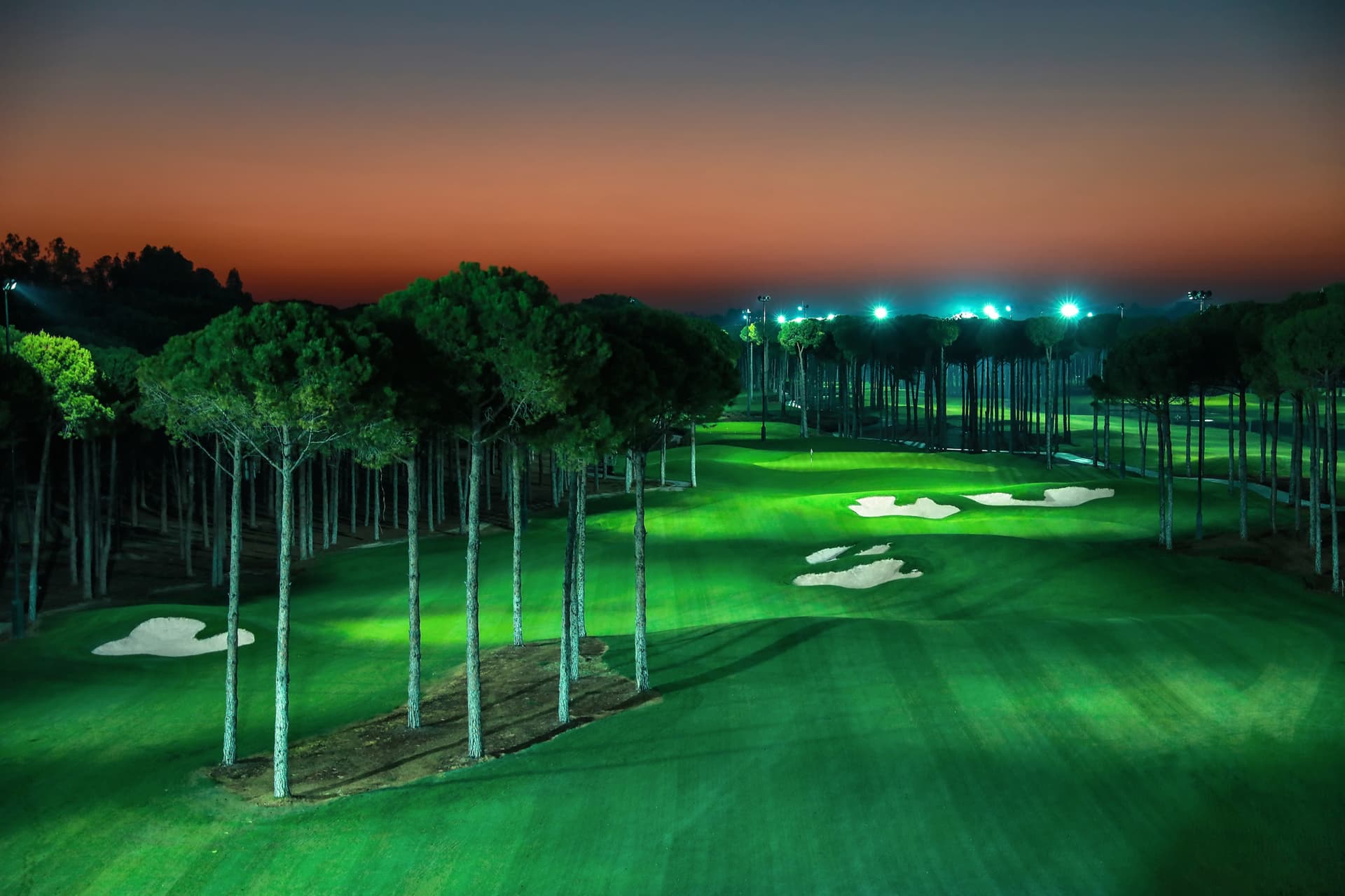 A well maintained fairway nestled with sand bunkers on the night golf course