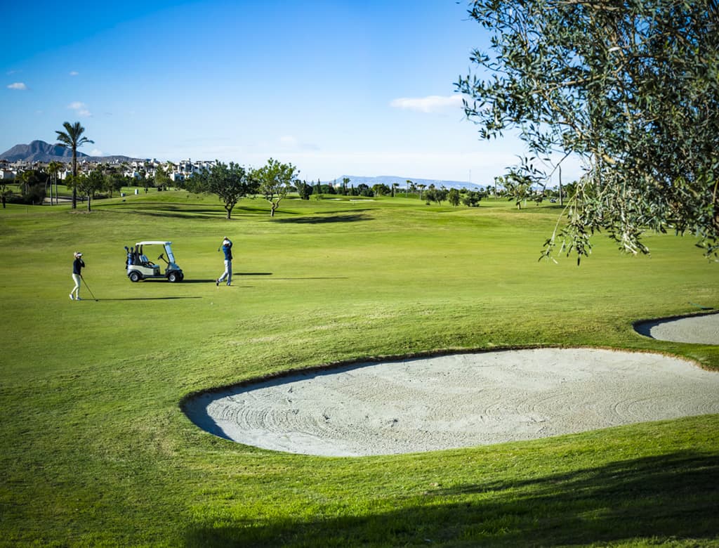 Two players playing in the middle of a wide fairway