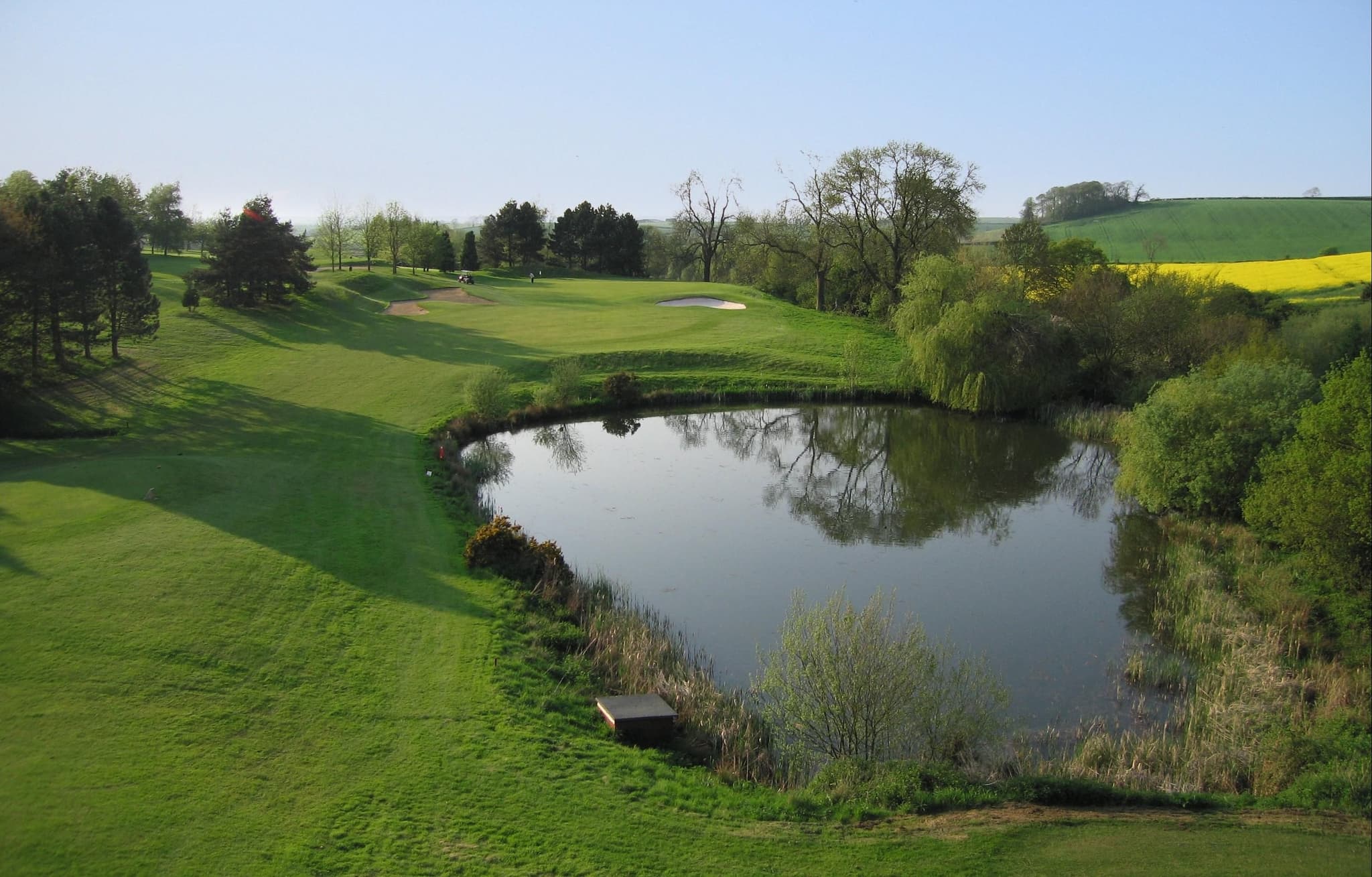 A well maintained fairway next to a water hazard
