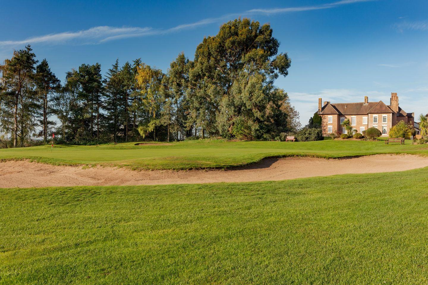 A well maintained fairway nestled with sand bunkers