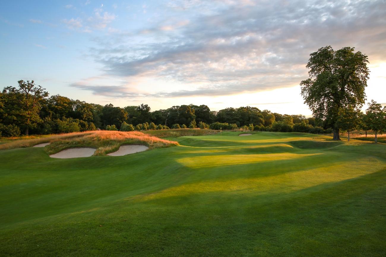 Sun shining over a well maintained fairway nestled with sand bunkers