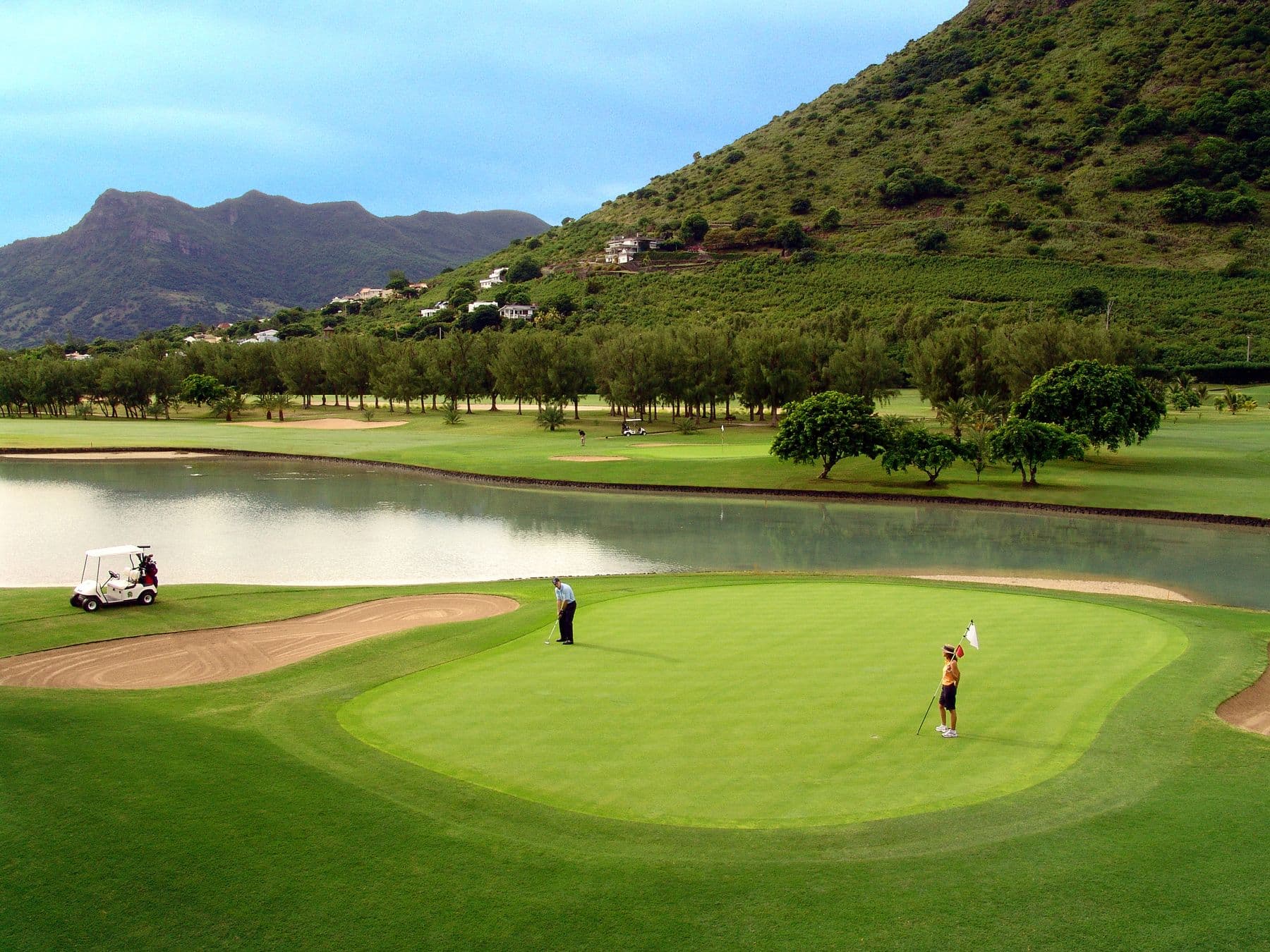 A manicured green next to a water hazard