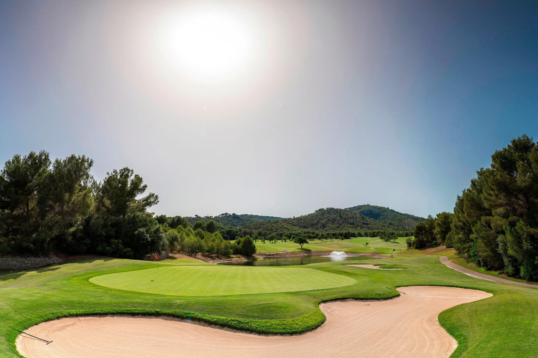 A smooth green next to a sand bunker