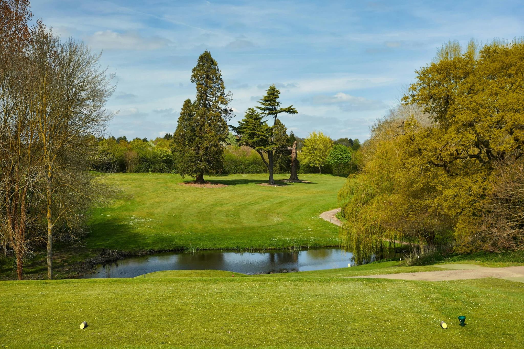 A well maintained fairway leading to a water hazard