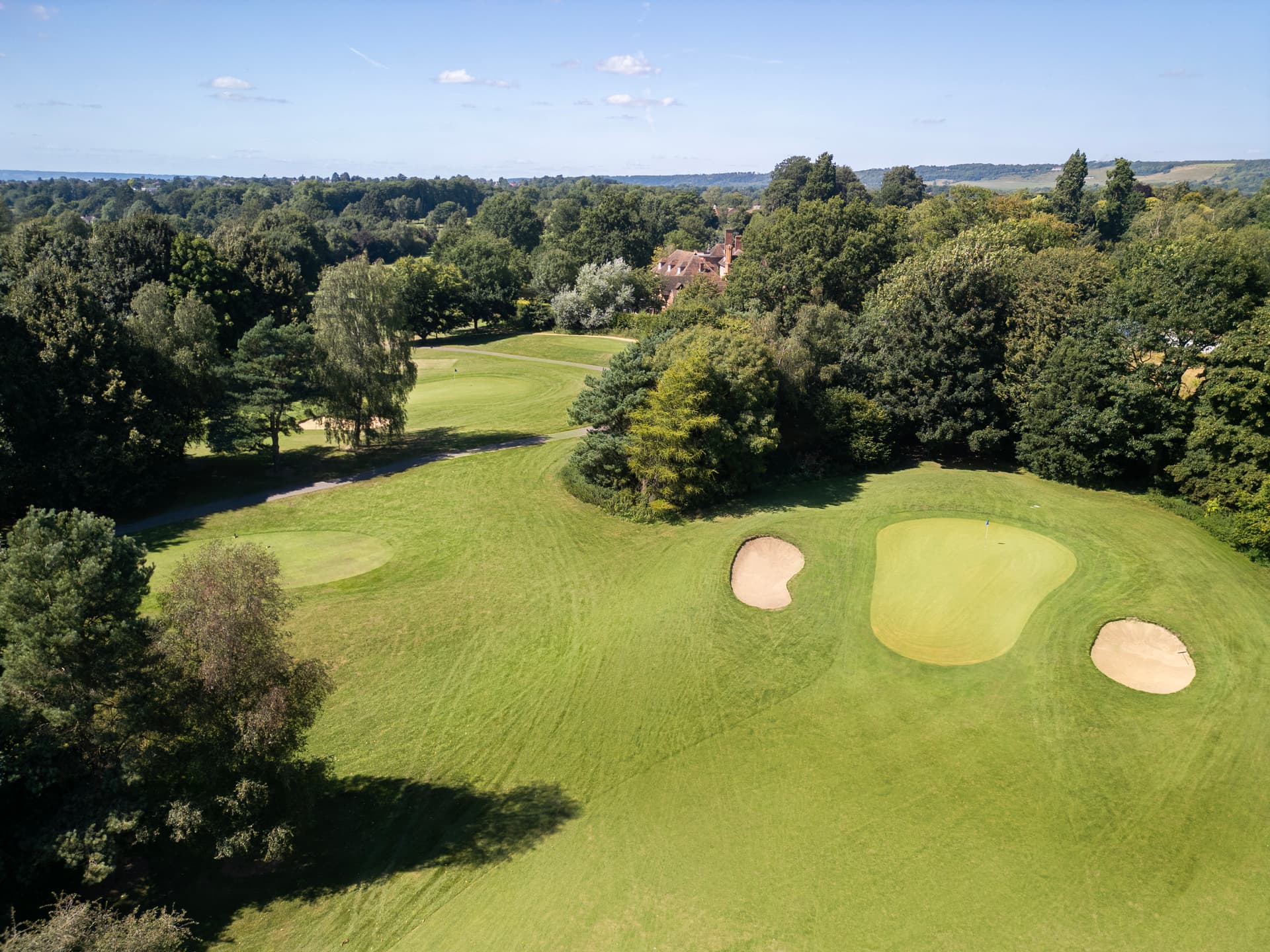 A well maintained fairway leading to a smooth green sandwiched by sand bunkers