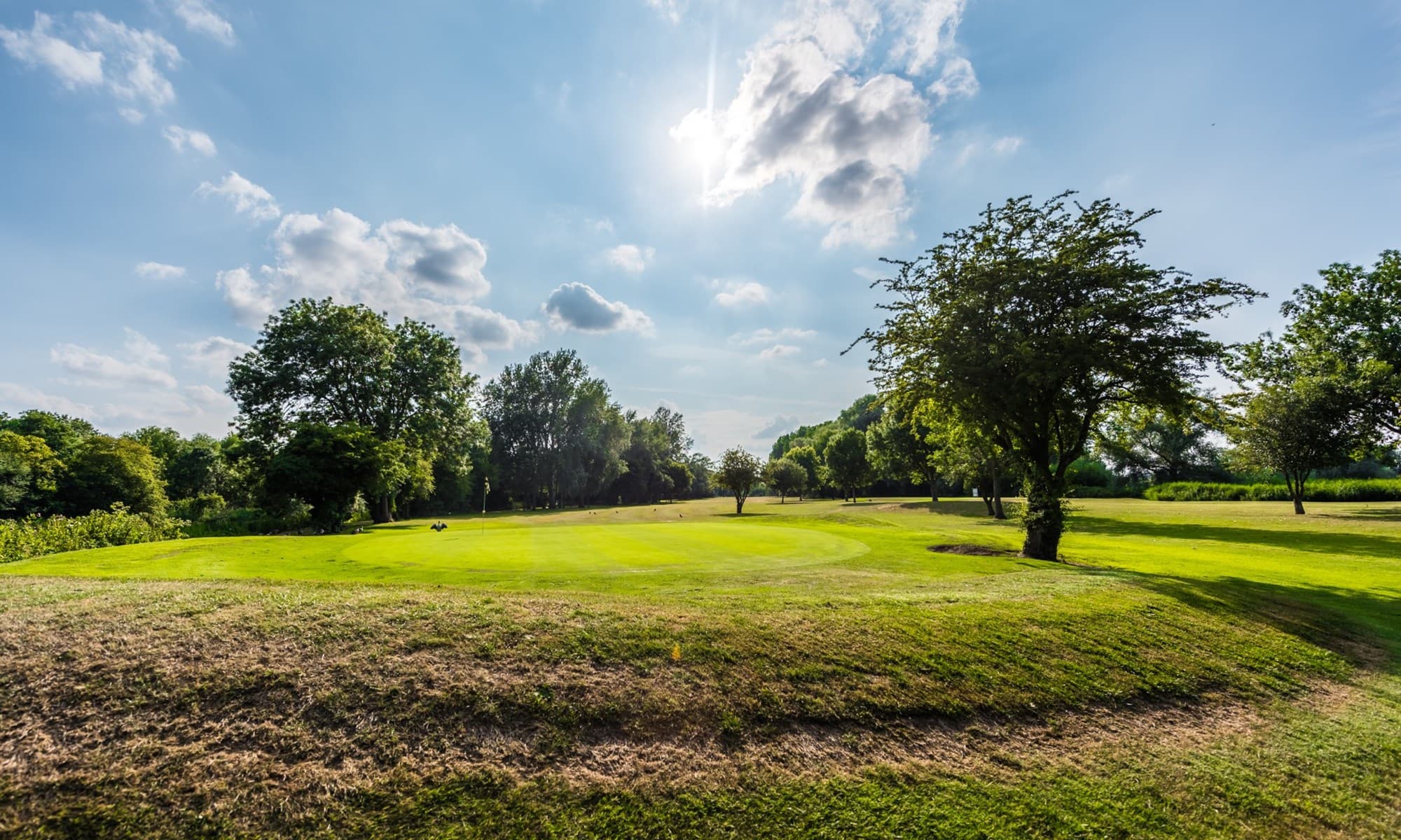 Sun shining onto a smooth green at the Willows Hotel at Wyboston Lakes