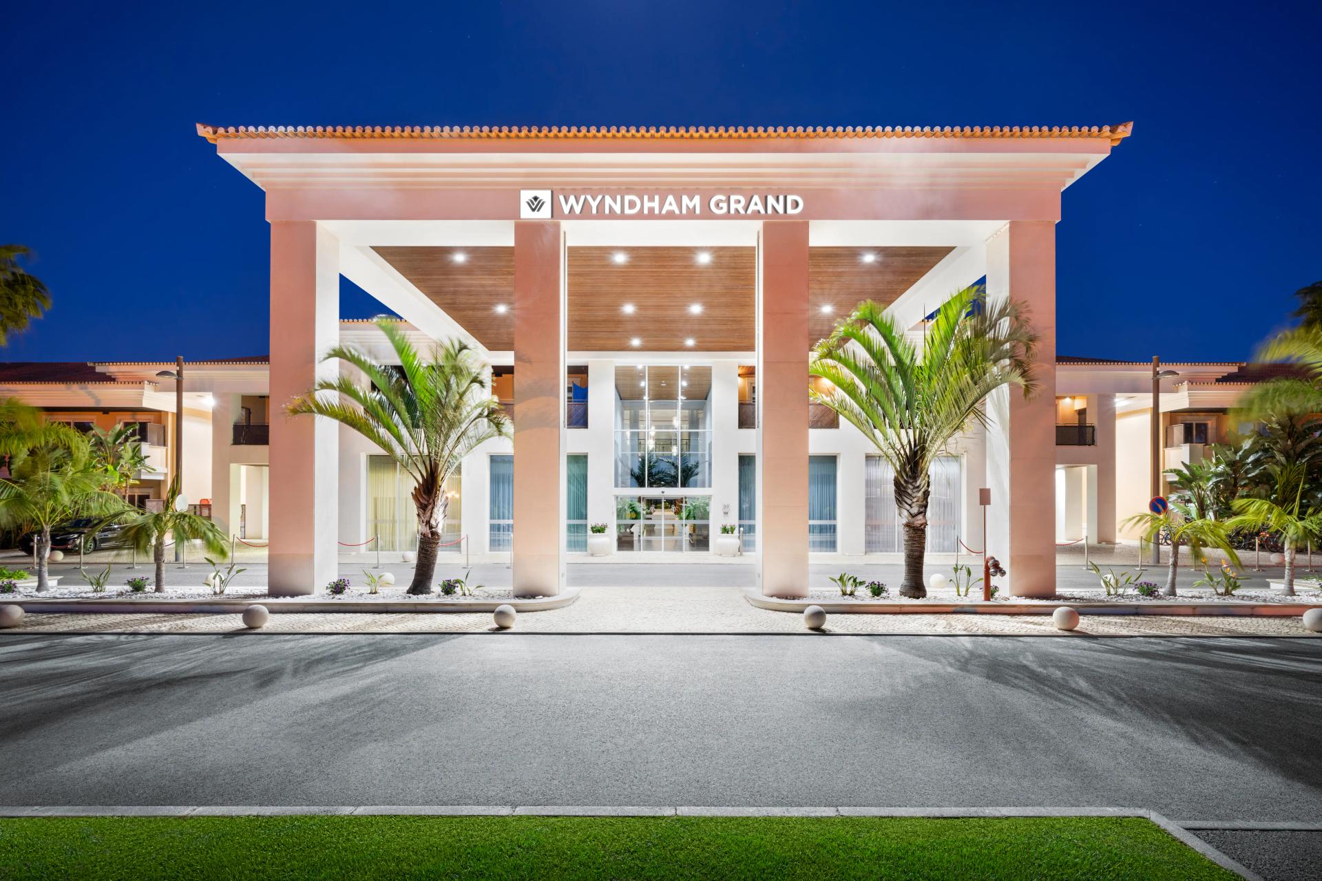 Exterior view of the entrance to Wyndham Grand Algarve lit up at night time