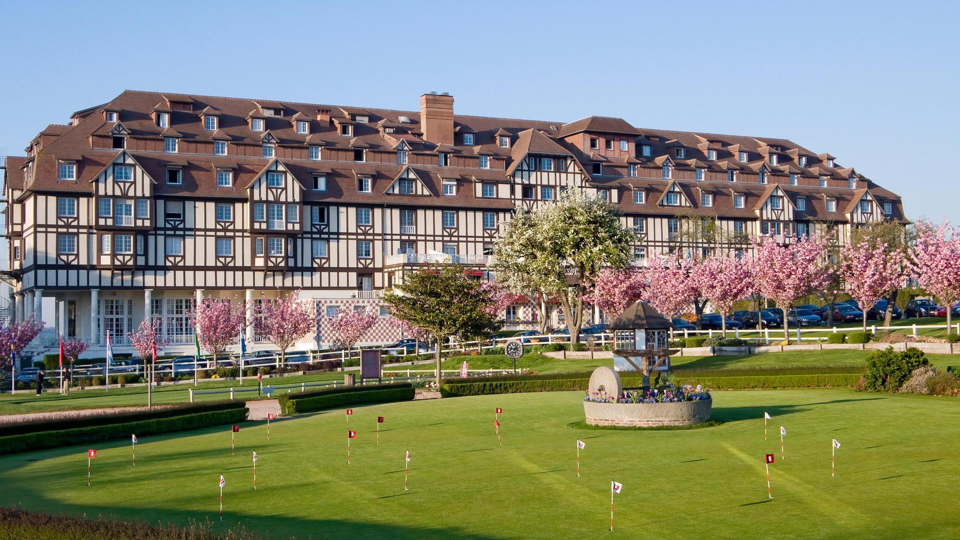 Panoramic view of the Hotel Barriere L'Hotel du Golf building overlooking the practice green