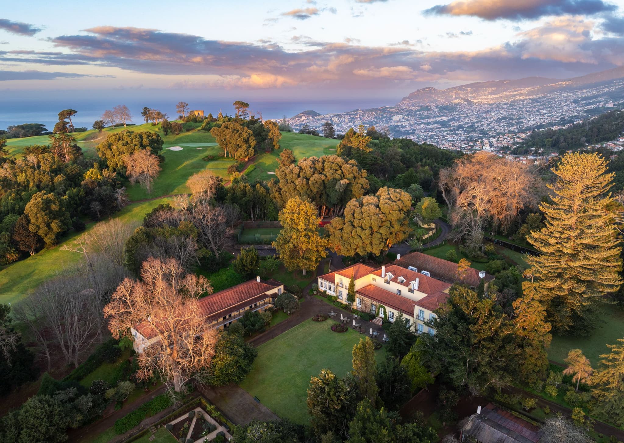 Aerial view of the coastal Hotel Casa Velha do Palheiro - Relais & Chateaux with its golf course in the background