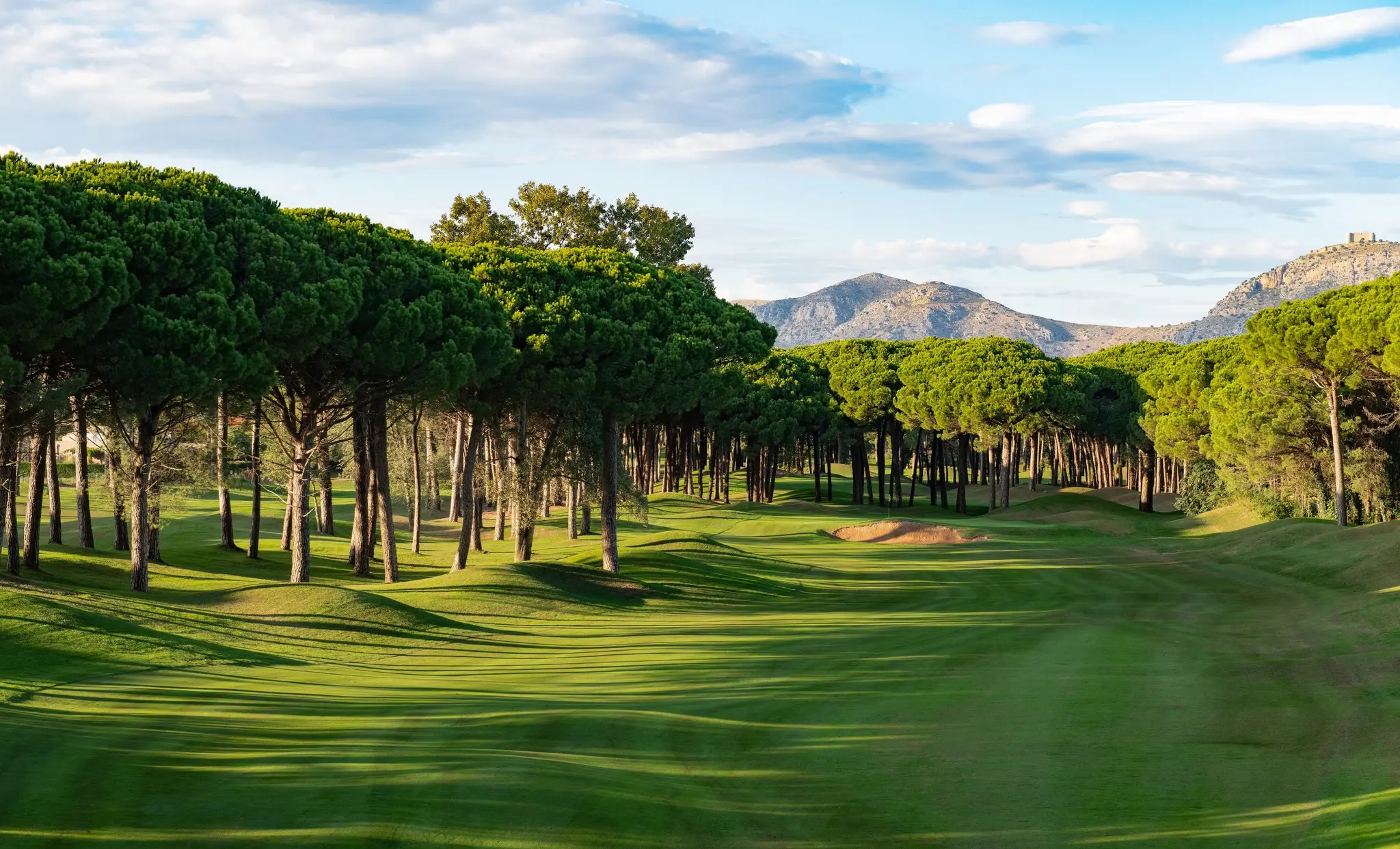 A well maintained fairway with mountain views in the distance