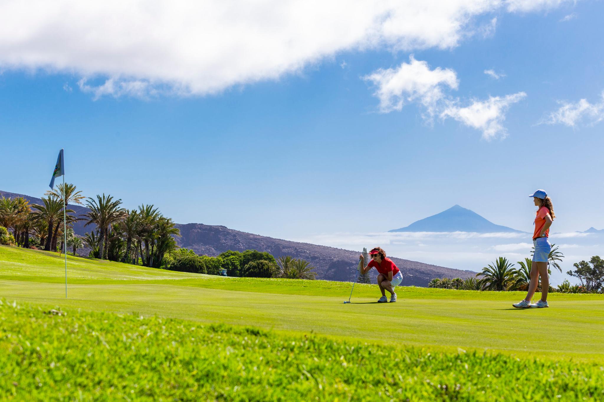 Golfers on a smooth green lining up their shot at Tecina Golf