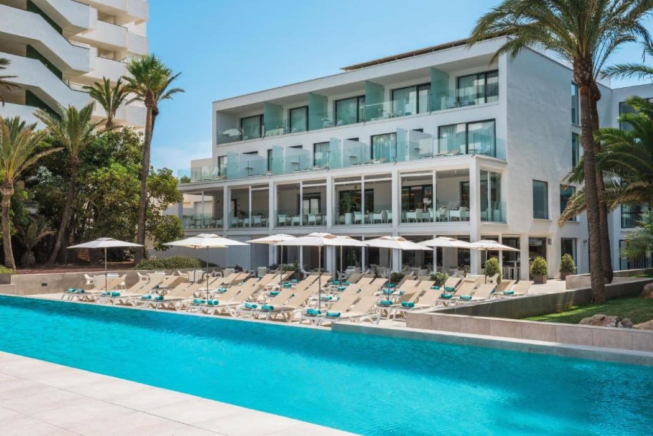 Outdoor swimming pool lined with sunbeds