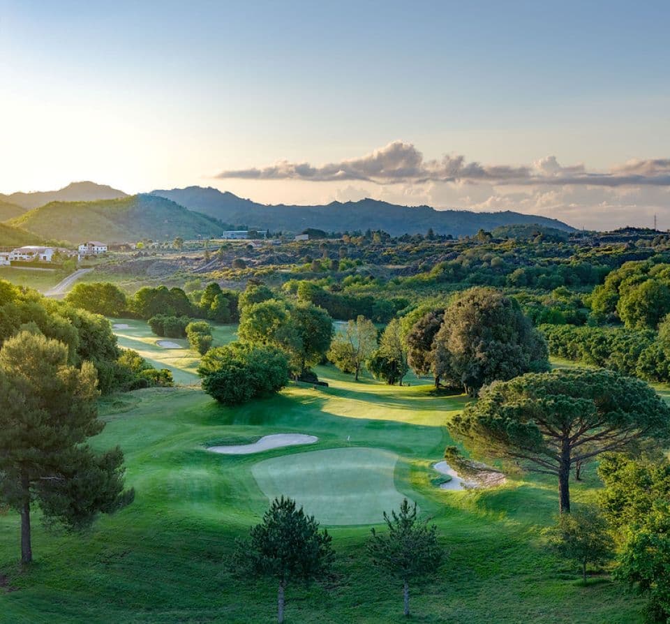 A well maintained fairway leading to a smooth green next to a sand bunker
