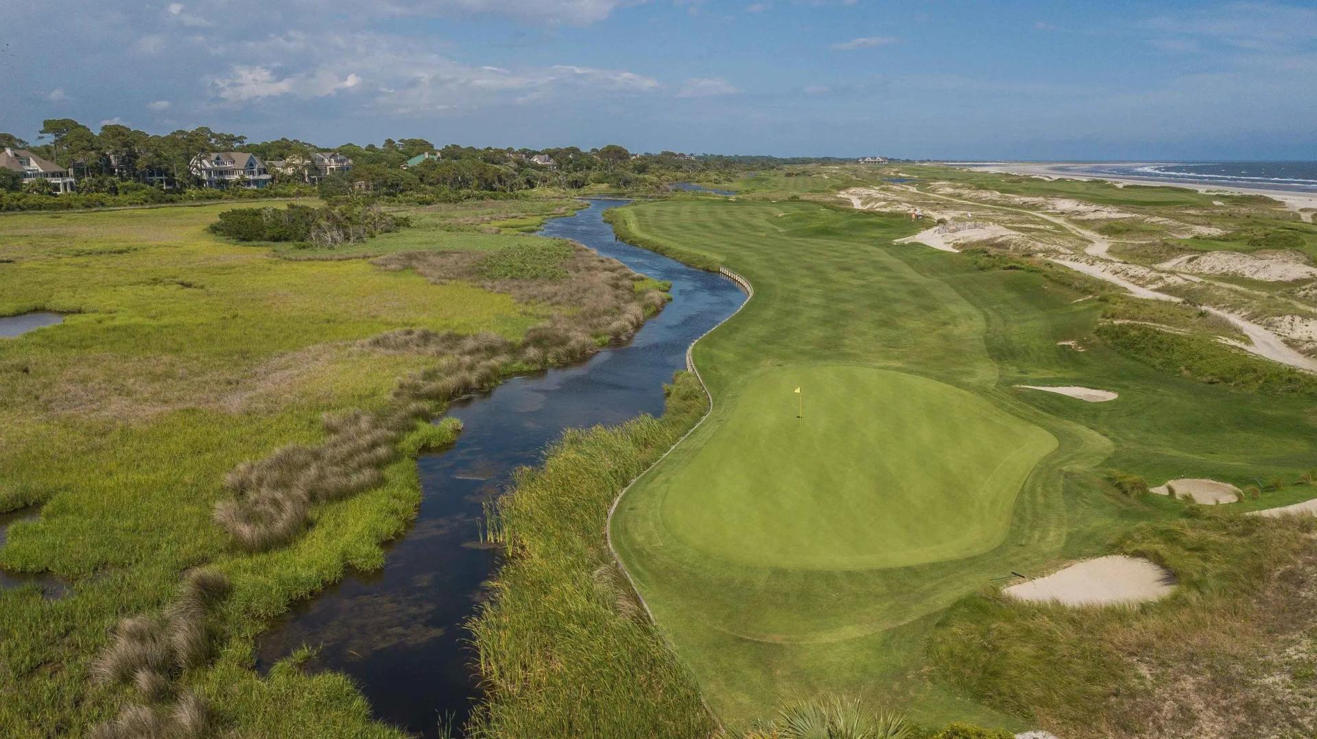 A well maintained fairway leading to a smooth green surrounded by sand bunkers