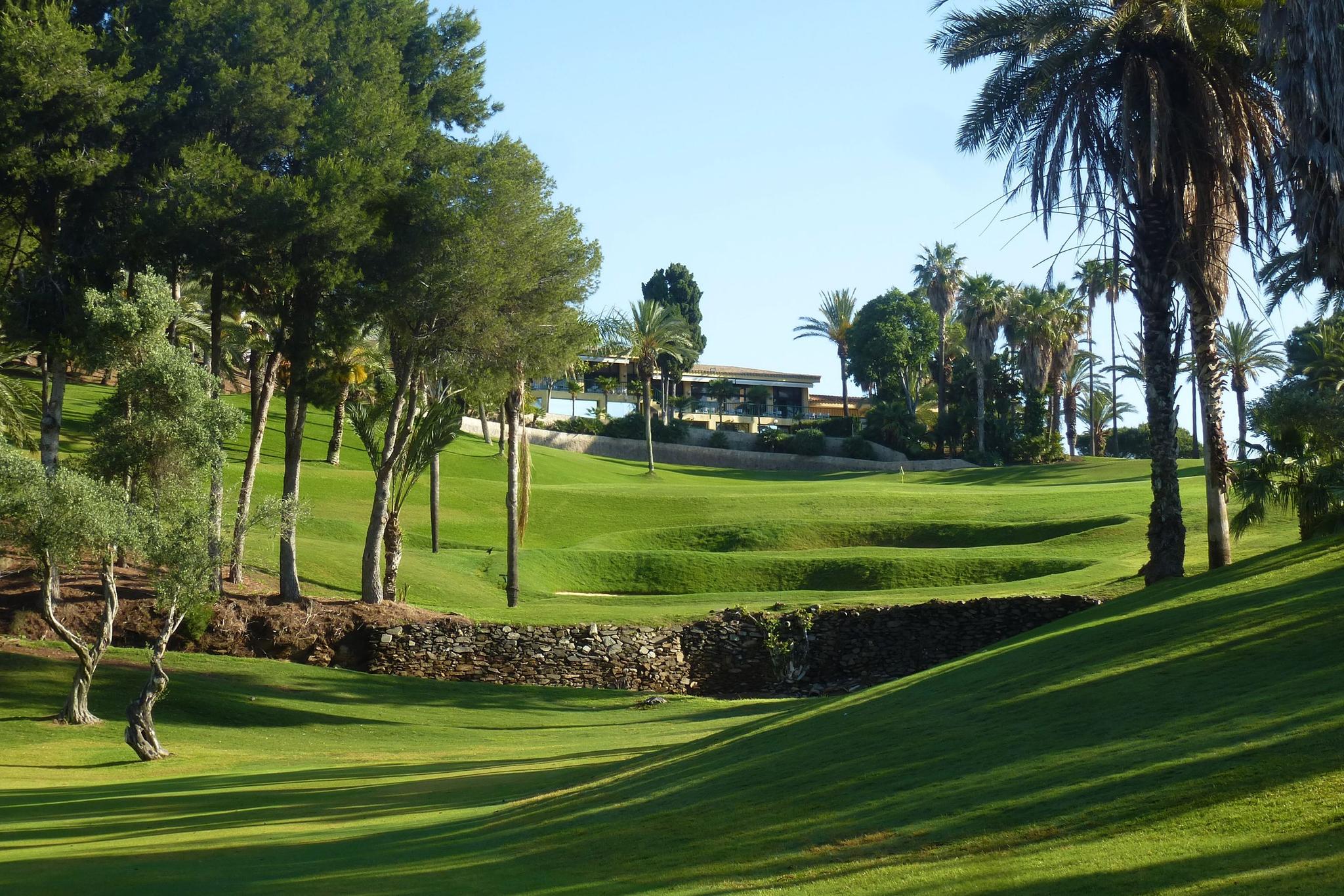 A well maintained fairway with the clubhouse in the distance
