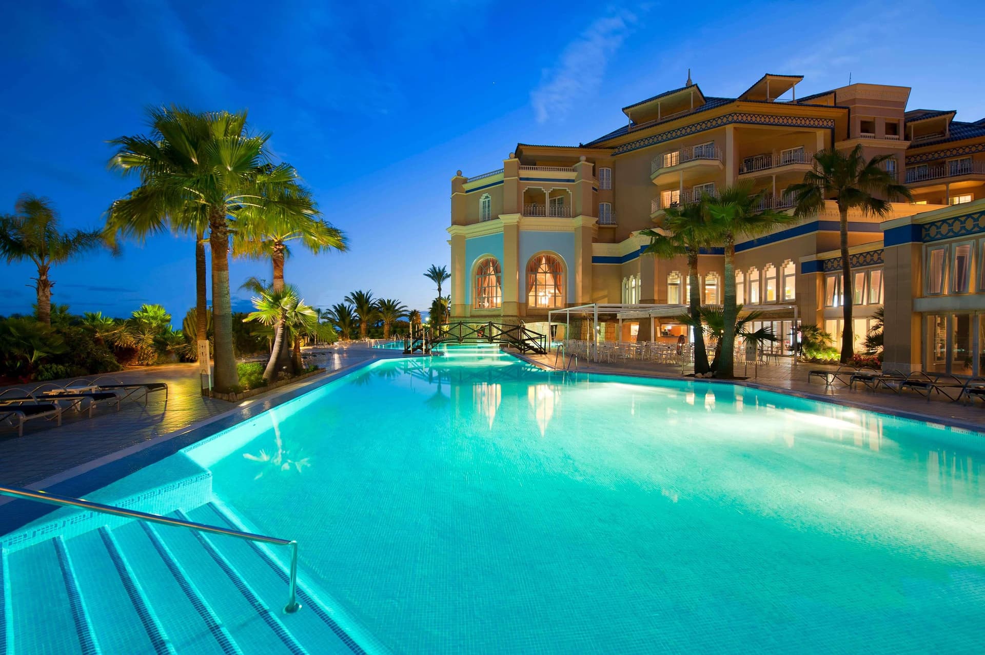 Outdoor pool at Melia Isla Canela lit up at night