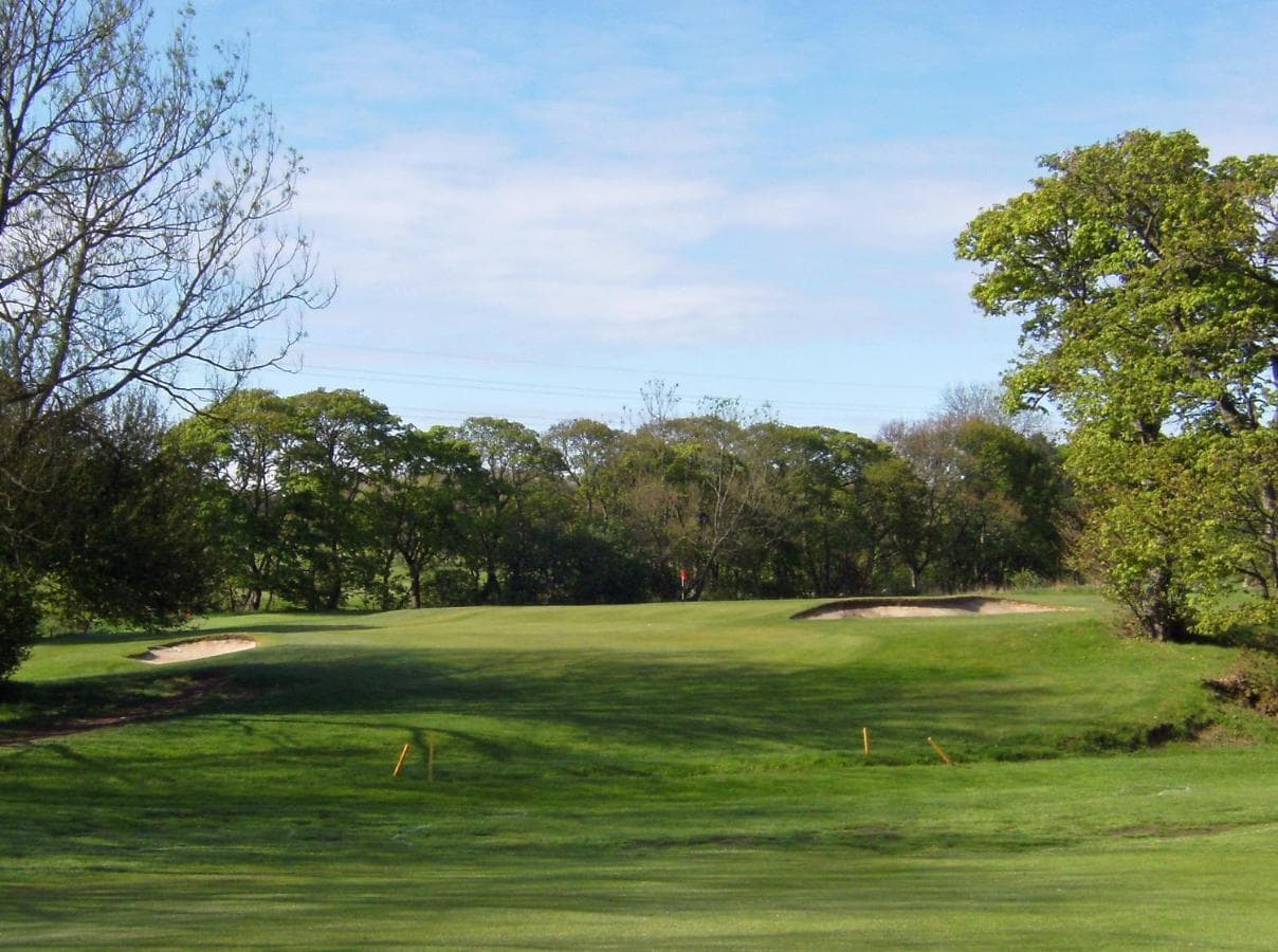Panoramic view of a well maintained fairway nestled with sand bunkers