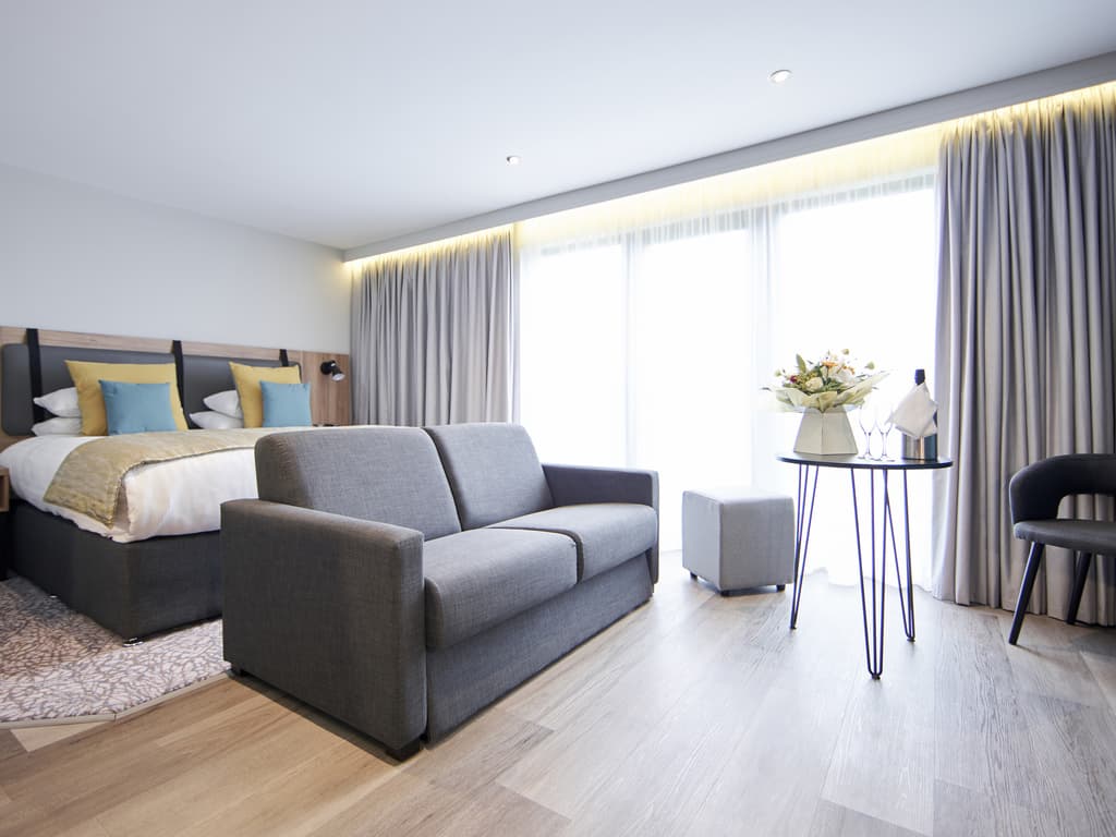 Double bed suite with a sofa at Mercure George Washington Hotel Golf and Spa