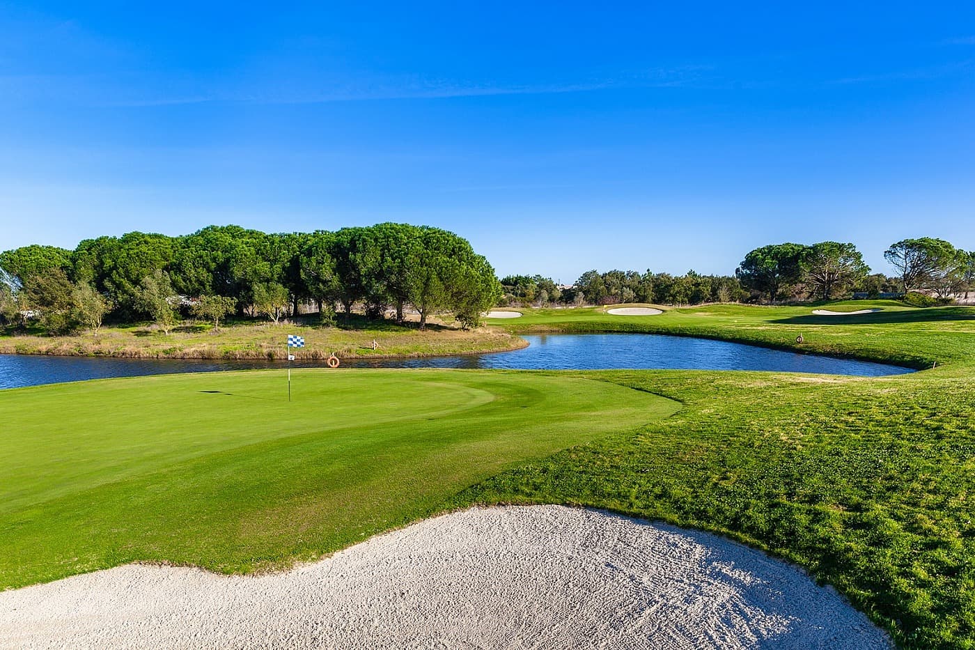 A smooth green sandwiched by a water hazard and sand bunker at Montado Hotel & Golf Resort