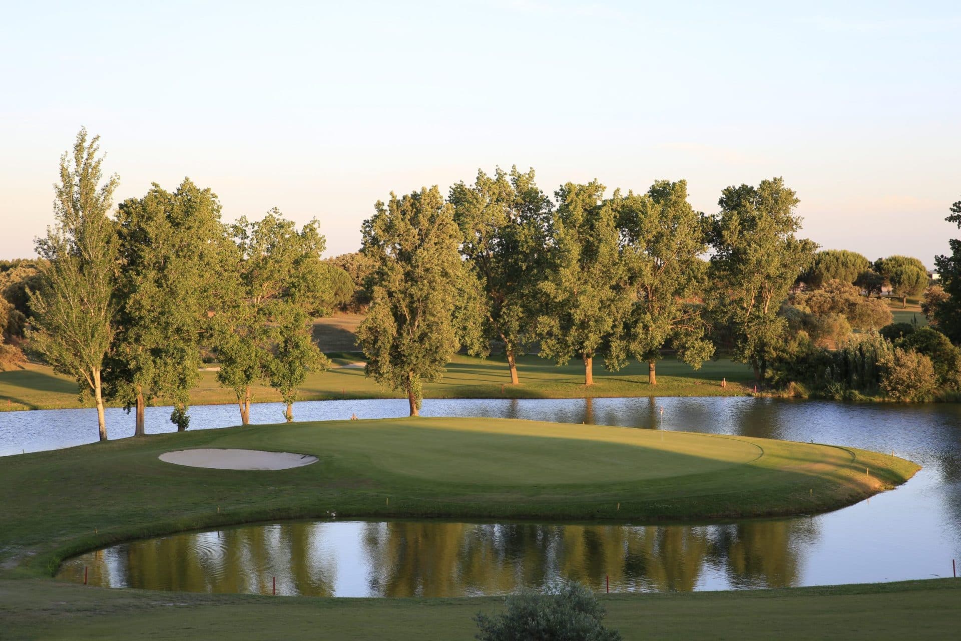 An island green nestled with a sand bunker on the Montado Hotel & Golf Resort golf course