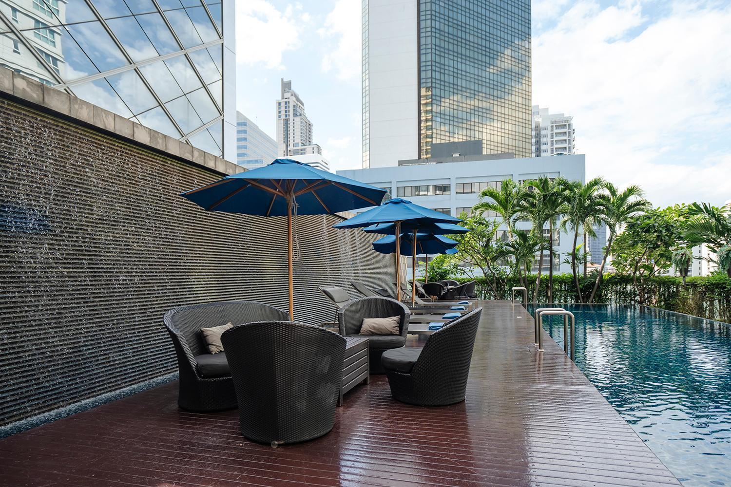 Outdoor swimming pool and lounging area at Hilton Bangkok Grande Asoke