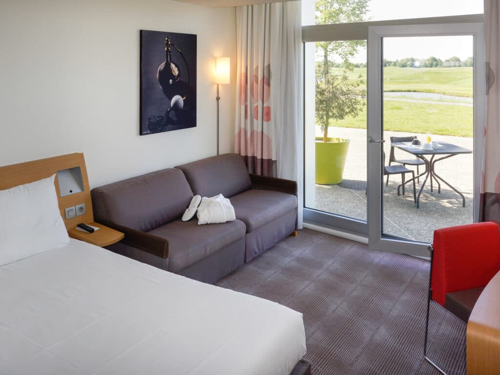 Double bed suite with outdoor patio space at Novotel Saint Quentin en Yvelines