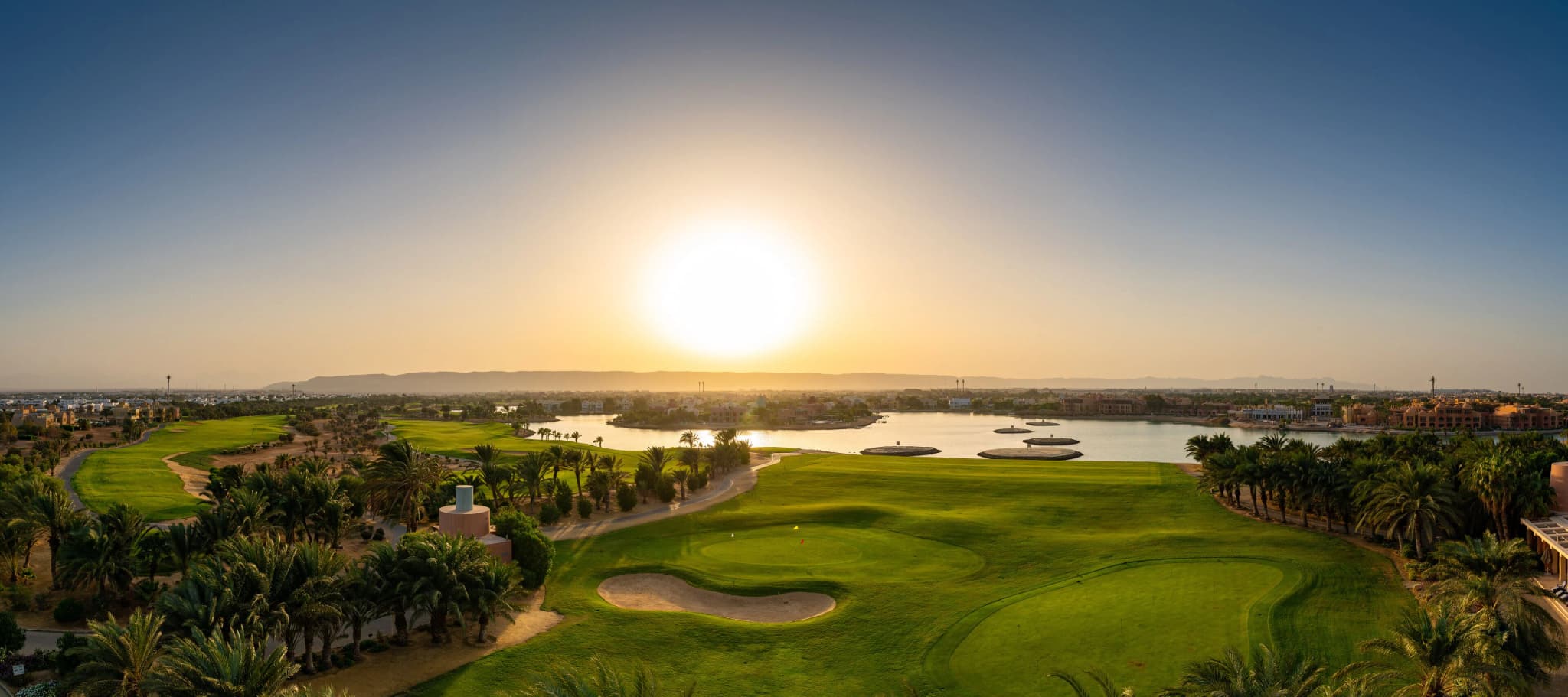 Sun shining over a well maintained fairway nestled with sand bunkers