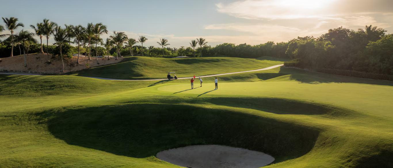 A well maintained fairway nestled with a deep sand bunker
