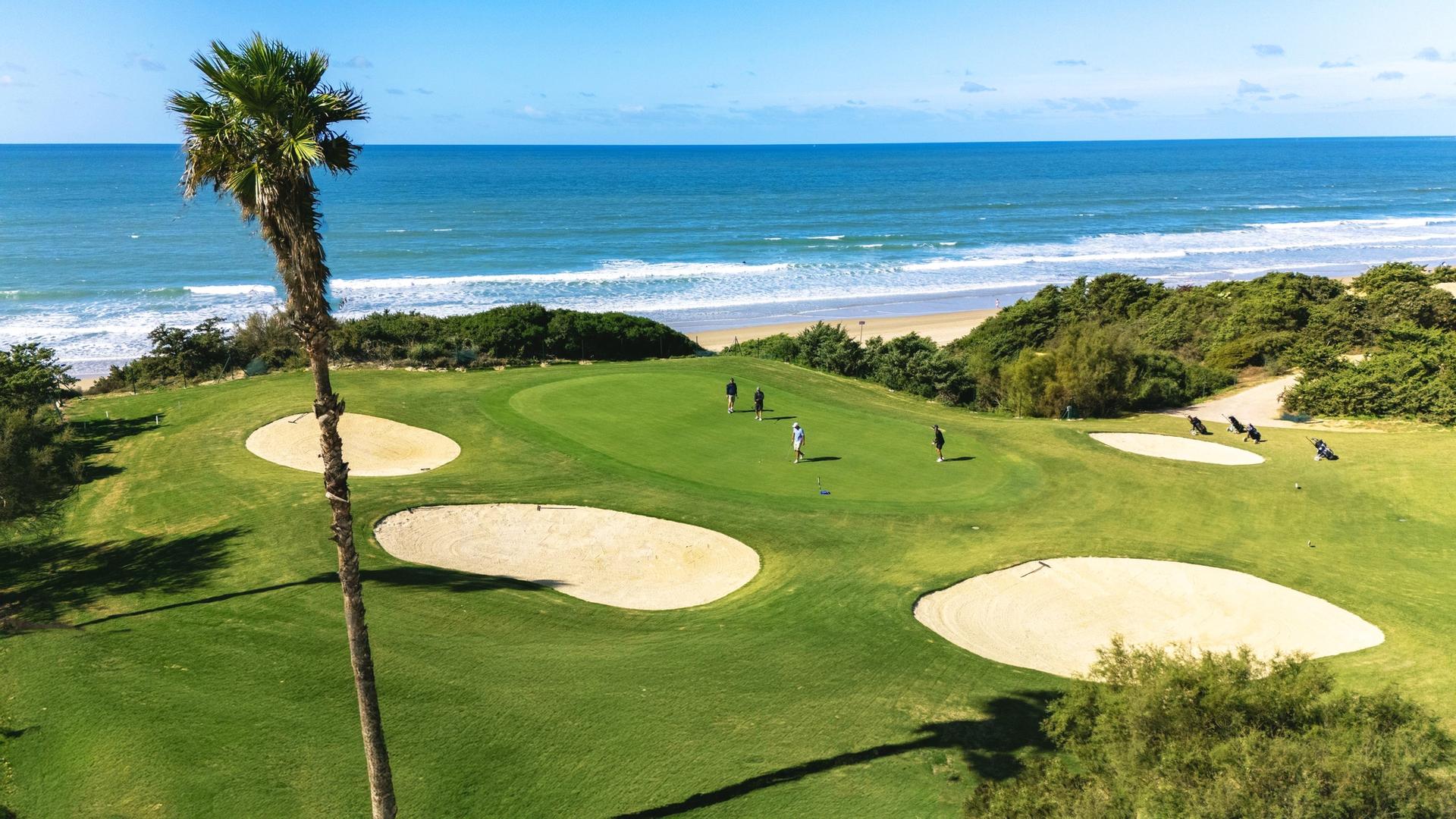 A smooth coastal green surrounded by sand bunkers