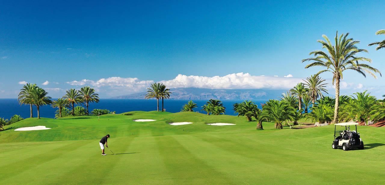 A well maintained fairway nestled with sand bunkers with coastal views