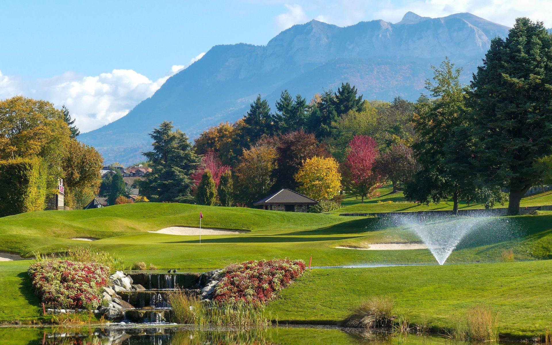 A well maintained fairway nestled with sand bunkers and a water hazard