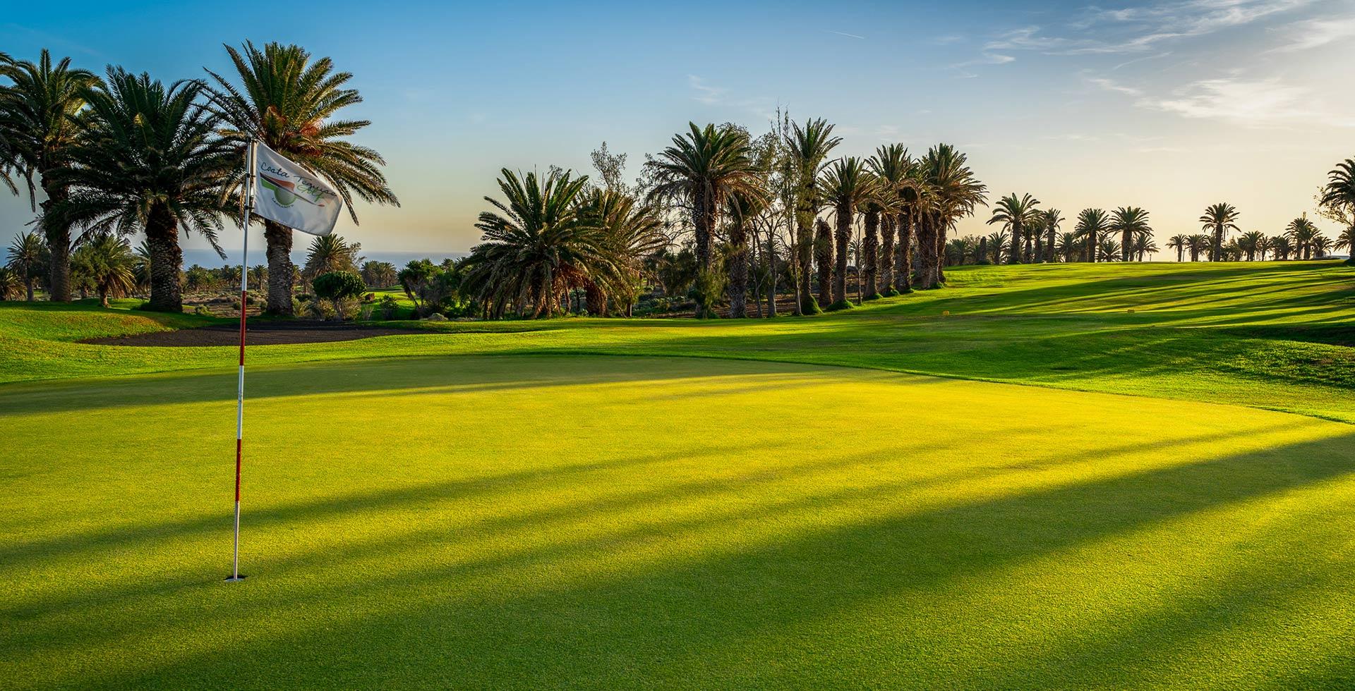 A smooth green with the sun shining over the course