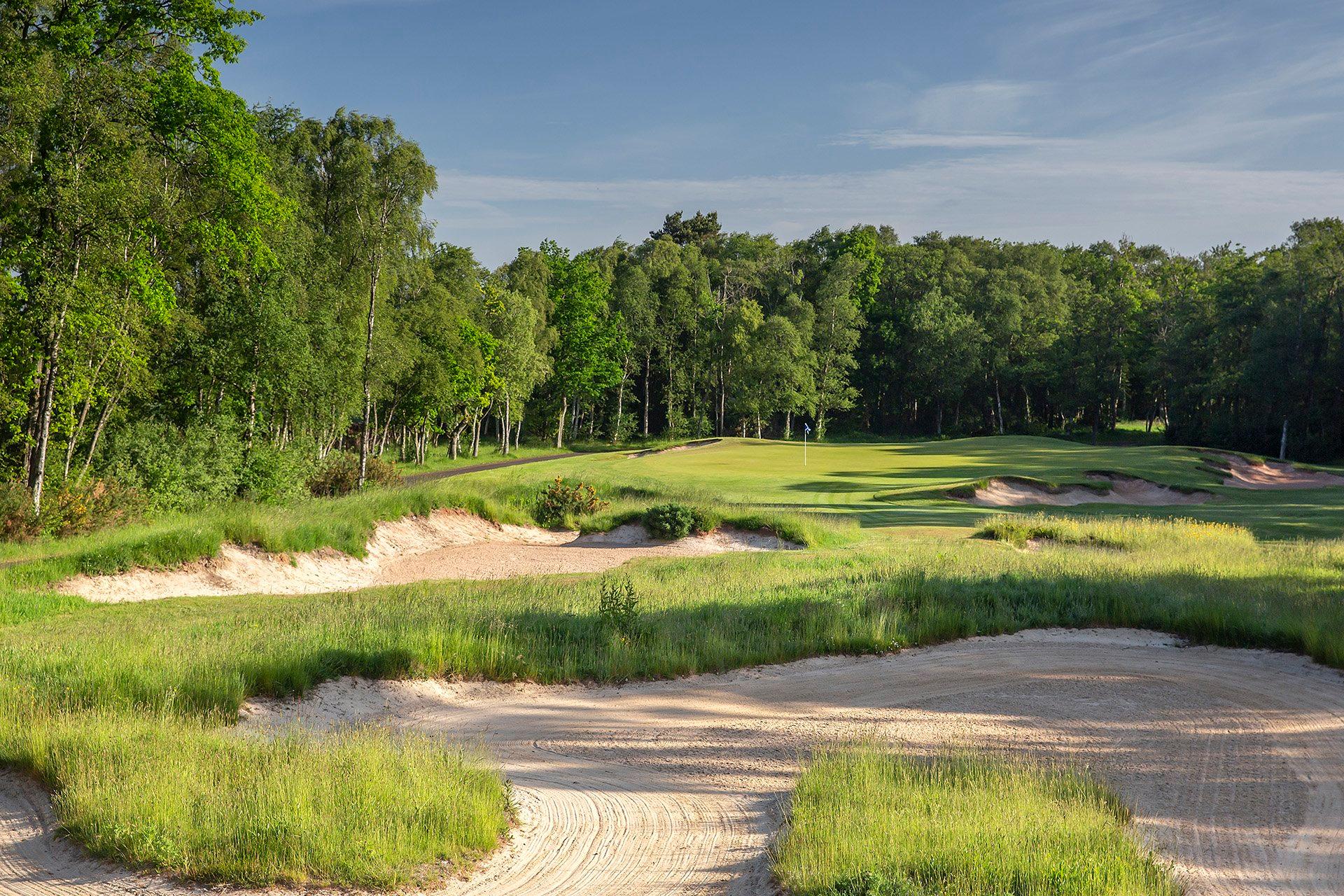 A well maintained fairway littered with sand bunkers