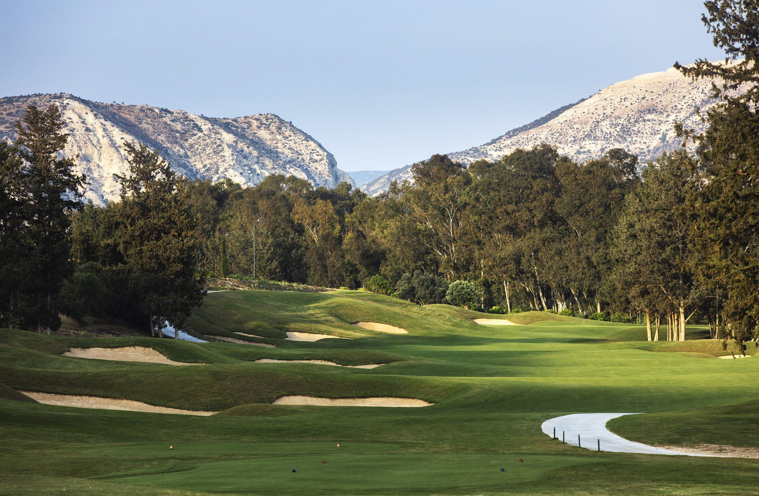 A well maintained fairway littered with sand bunkers