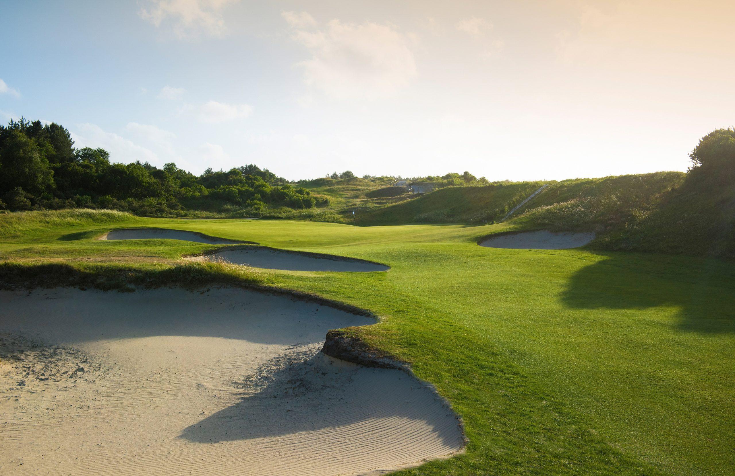 A well maintained fairway nestled with sand bunkers