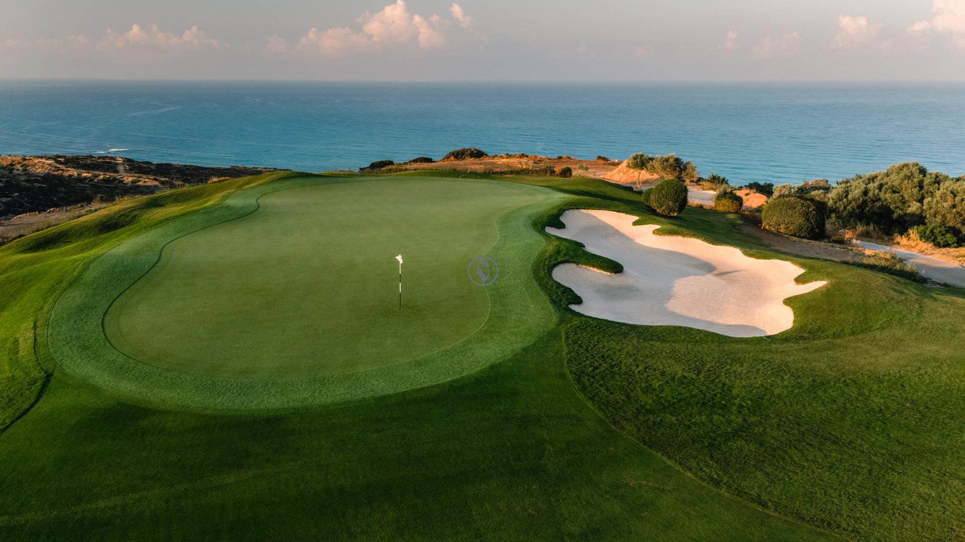 A well maintained coastal green with sand bunker
