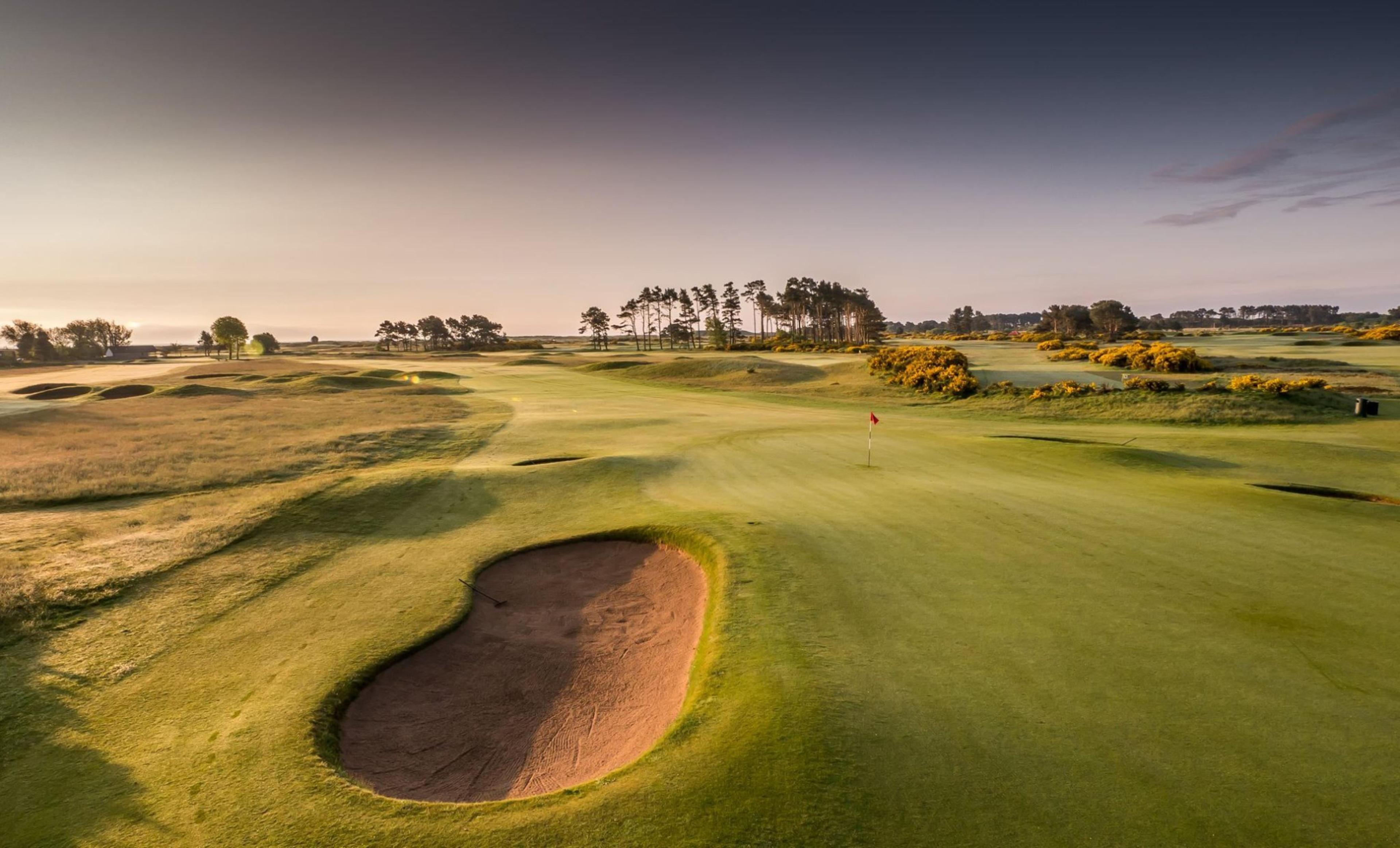 A well maintained fairway nestled with sand bunkers