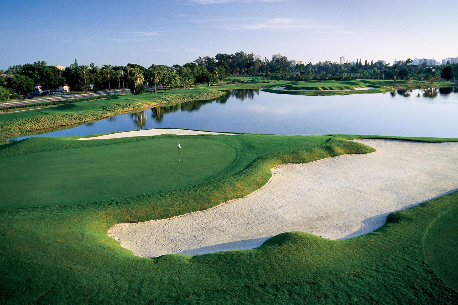 Overhead view of a smooth green next to a large sand bunker and water hazard
