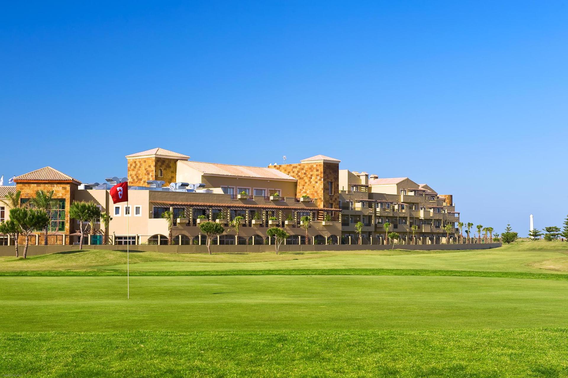 Panoramic view of Barcelo Costa Ballena Golf & Spa overlooking a smooth green with a red flagstick