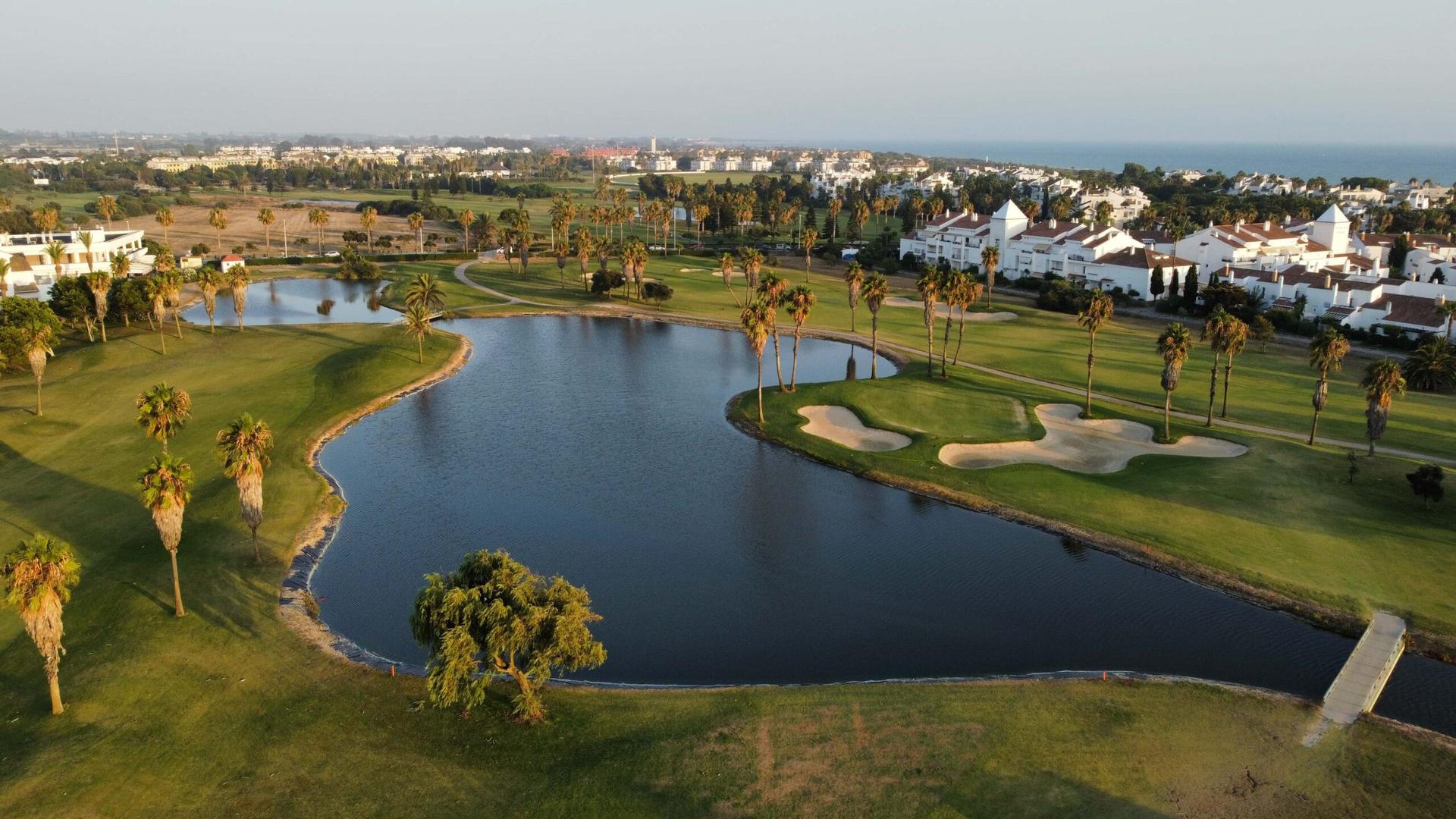 Overhead view of a well maintained fairway next to a water hazard