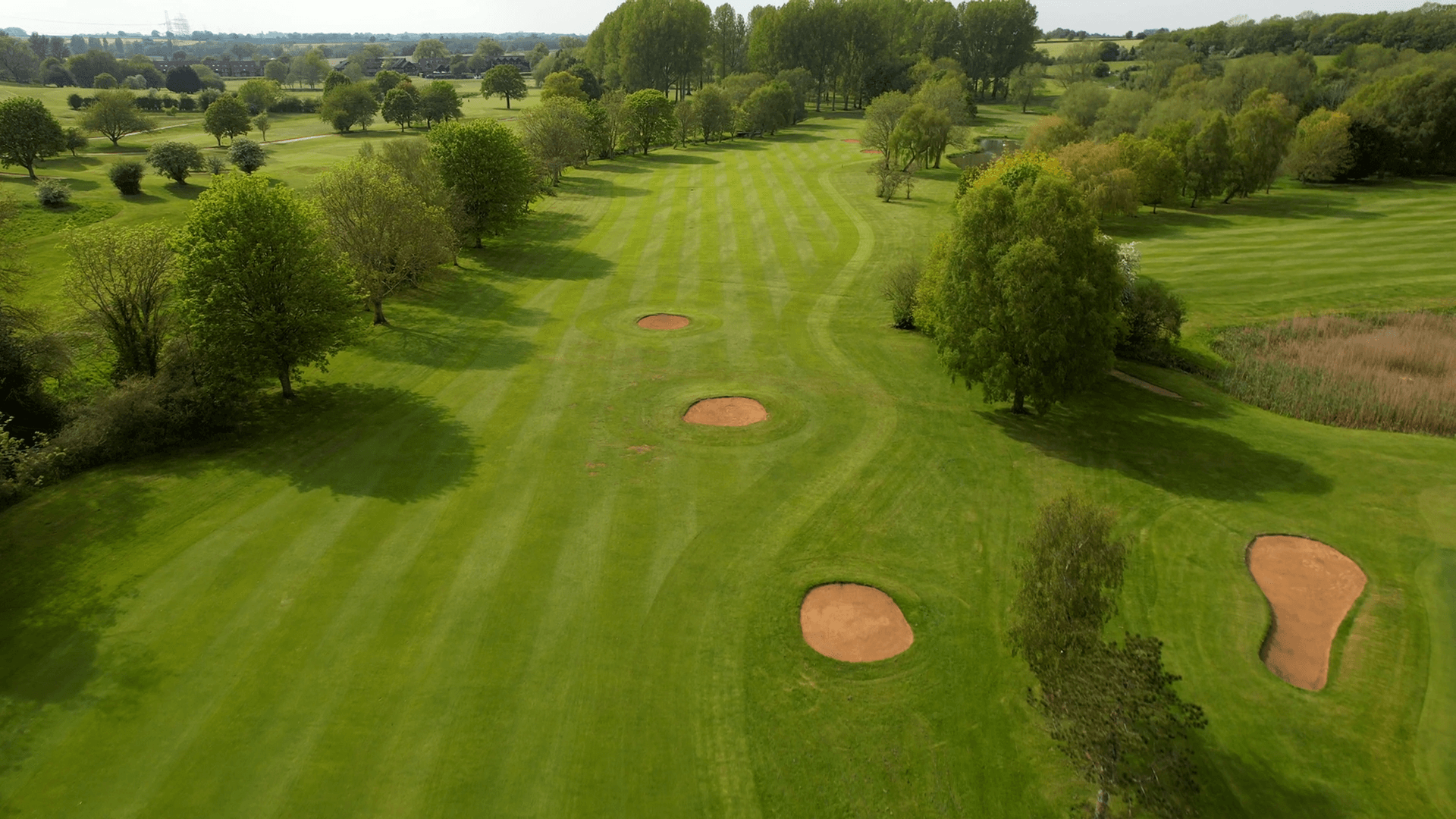 Birdseye view of a well maintained fairway nestled with sand bunkers