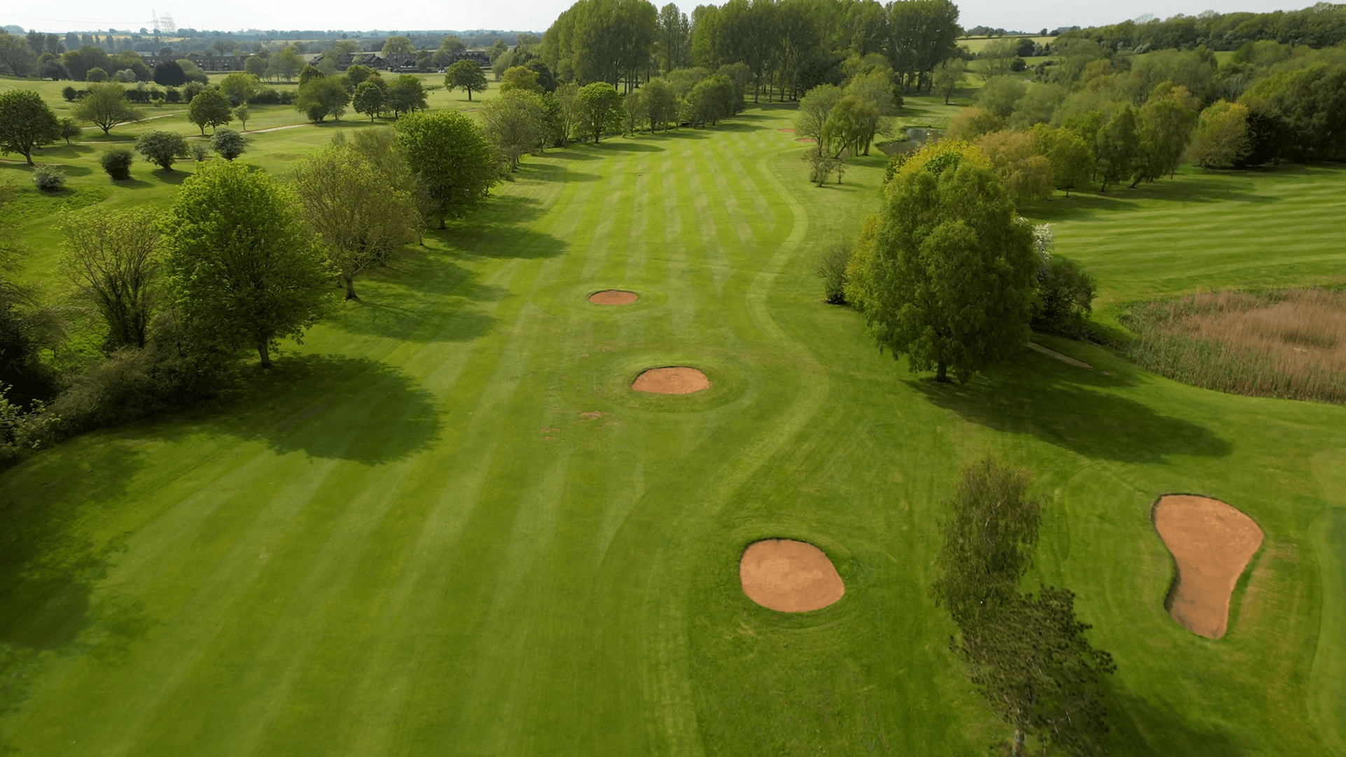 Birdseye view of a well maintained fairway nestled with sand bunkers