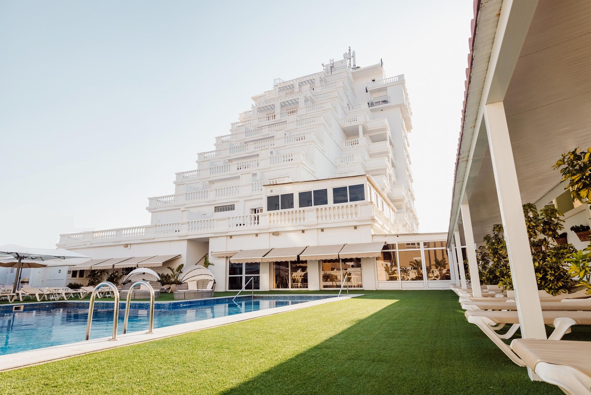 Panoramic view of the Delfines Hotel & Suites building overlooking the outdoor swimming pool