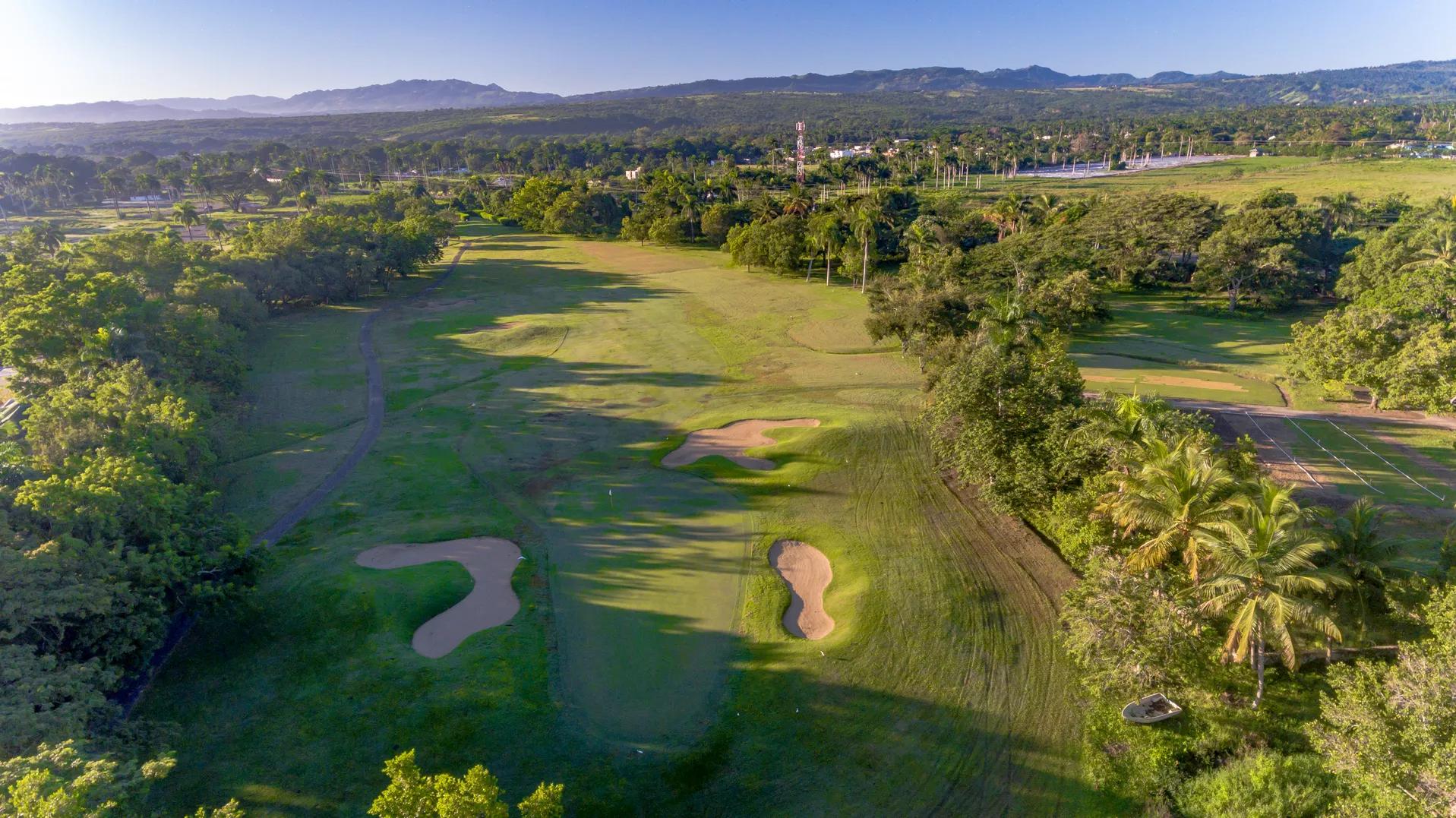 A well maintained fairway leading to a smooth green surrounded by sand bunkers