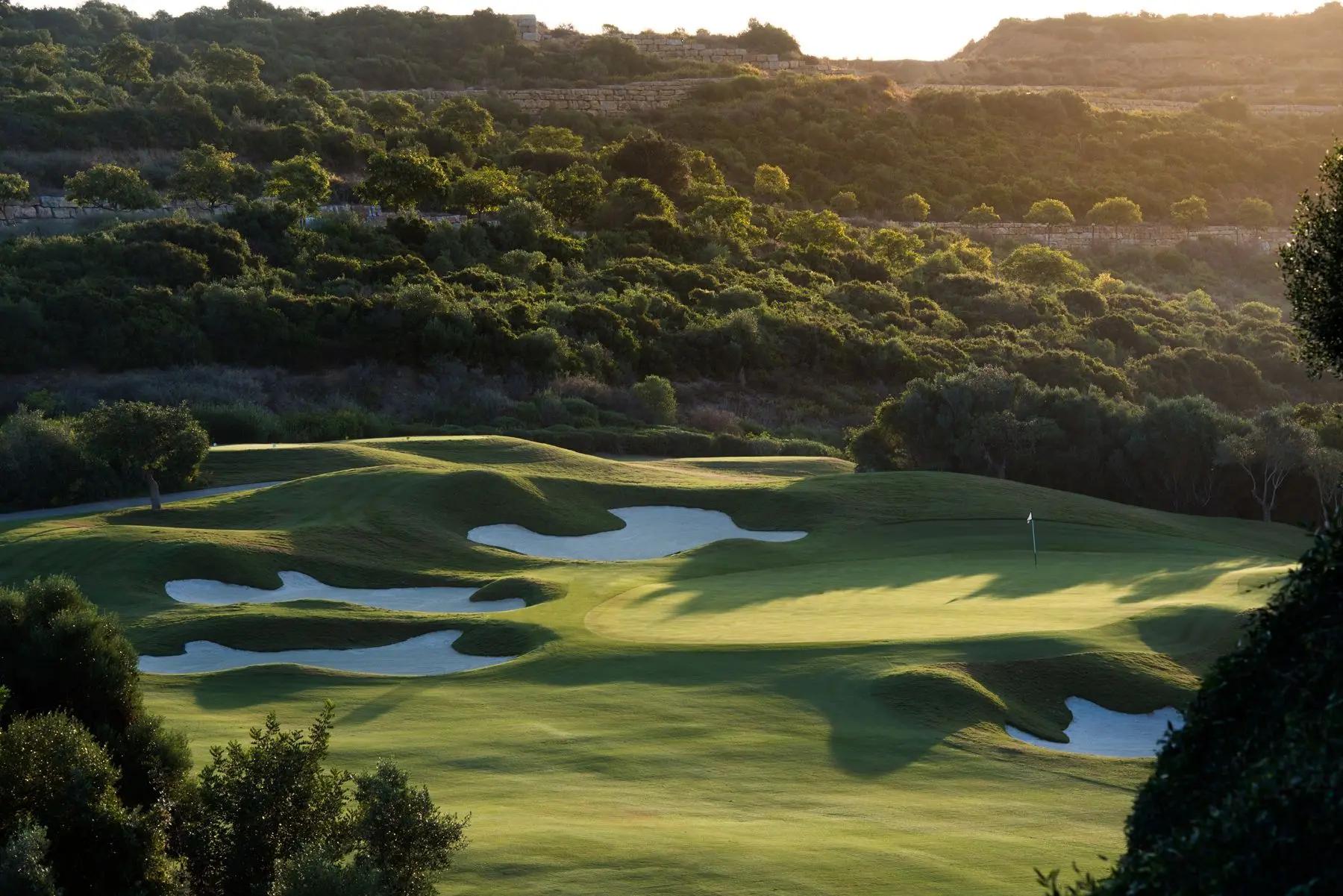 A fairway nestled with sand bunkers leading to a smooth green