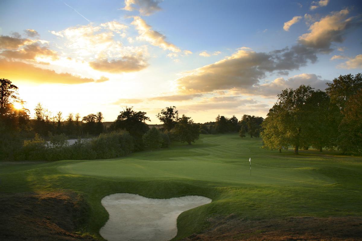 Panoramic view of a smooth green next to a sand bunker